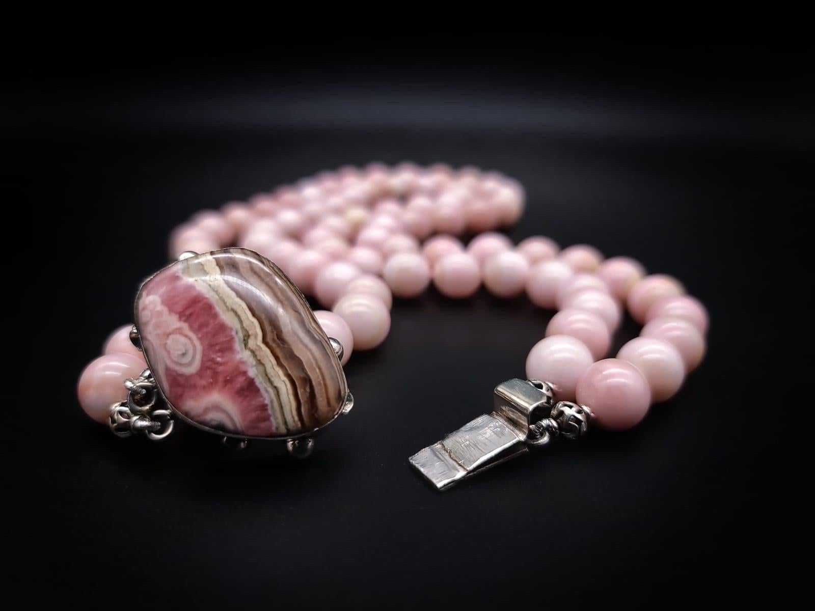 Einzigartig

Ungewöhnlicher rosa Onyx  2 Stränge mit aufeinander abgestimmten 12m.m Perlen. Schmeichelhafte zartrosa Perlen mit sanften Bändern, einzeln geknotet, umgeben ein Exemplar des geschliffenen Rhodochrosit-Steins, eingefasst in eine