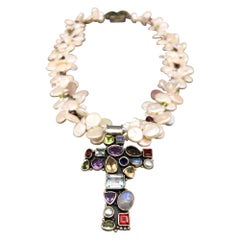 A.Jeschel Precious stone encrusted Silver Cross anchors a Pearl Necklace.