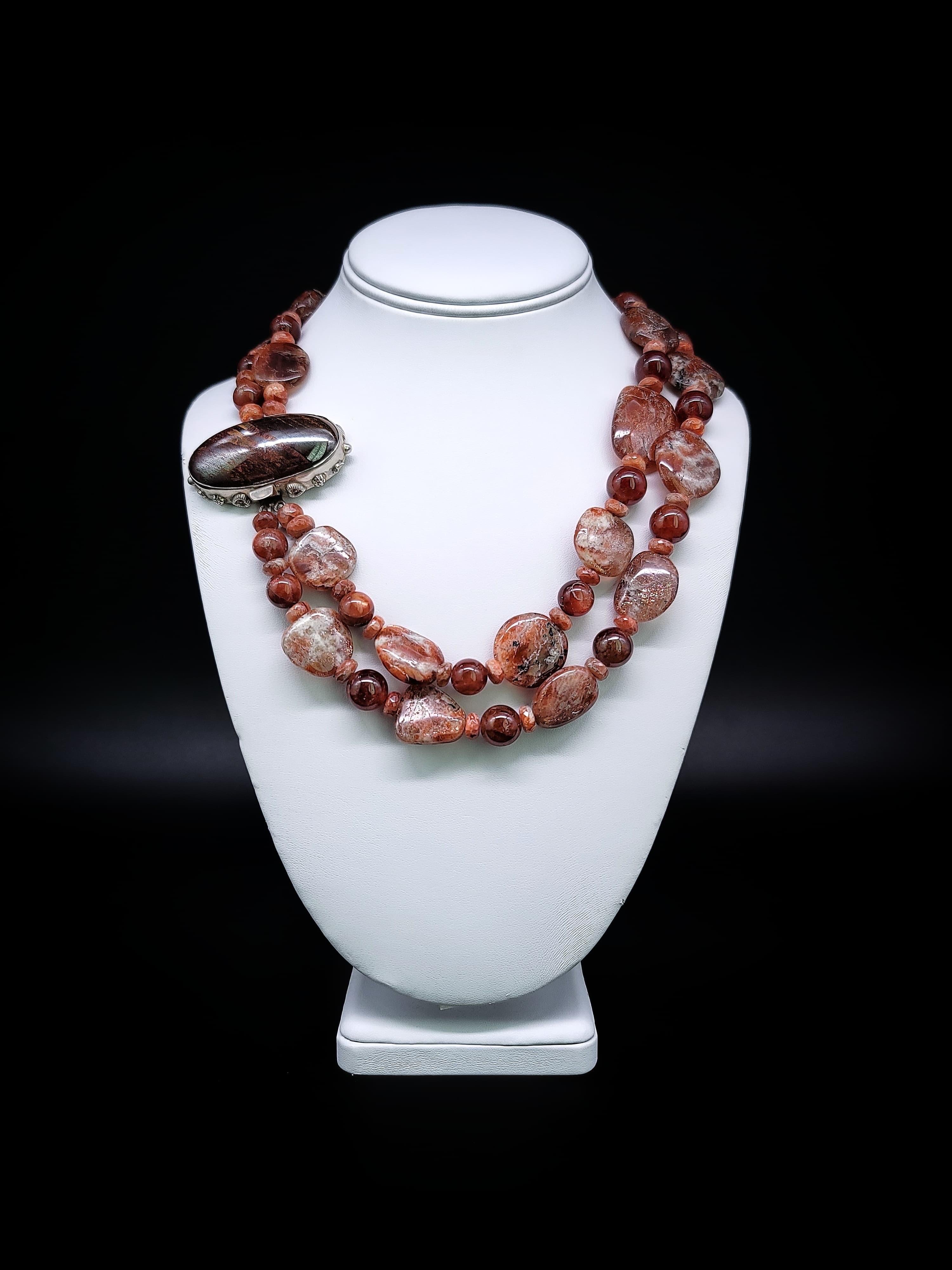 Radiant Sunstone Elegance- a necklace that intertwines sophistication and natural beauty. This unique masterpiece features not one, but two strands of meticulously hand-knotted silk, each adorned with a mesmerizing array of sunstone specimens and