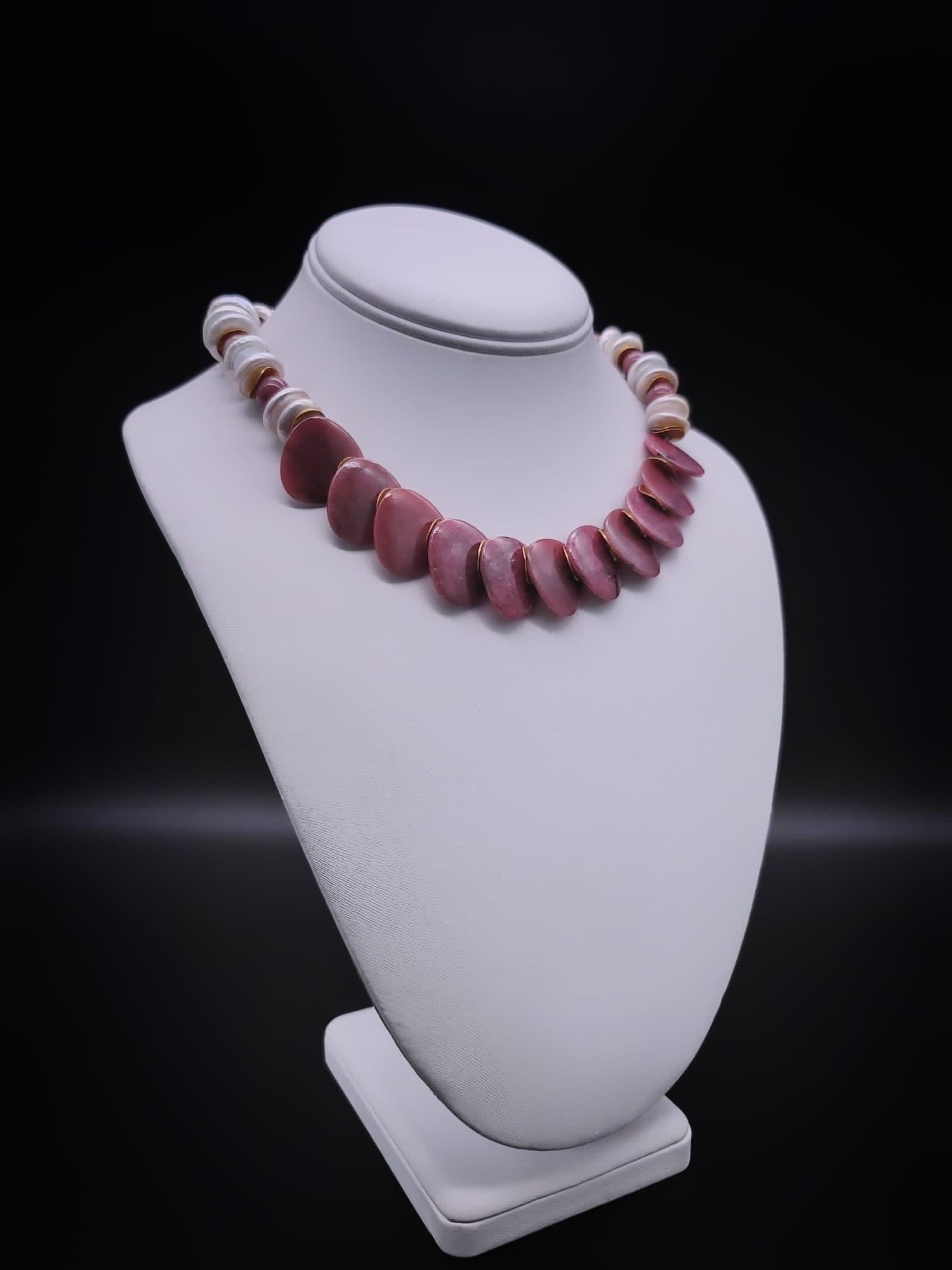 One-of-a-Kind
 Rich rosy colored rhodochrosite 
 Polished, in imaginatively cut tabs forming a bib, hung from a mixed strand of variegated pink and white rhodochrosite beads with 10 m.m coin pearls and vermeil c.z rondels. The clasp is vintage glass