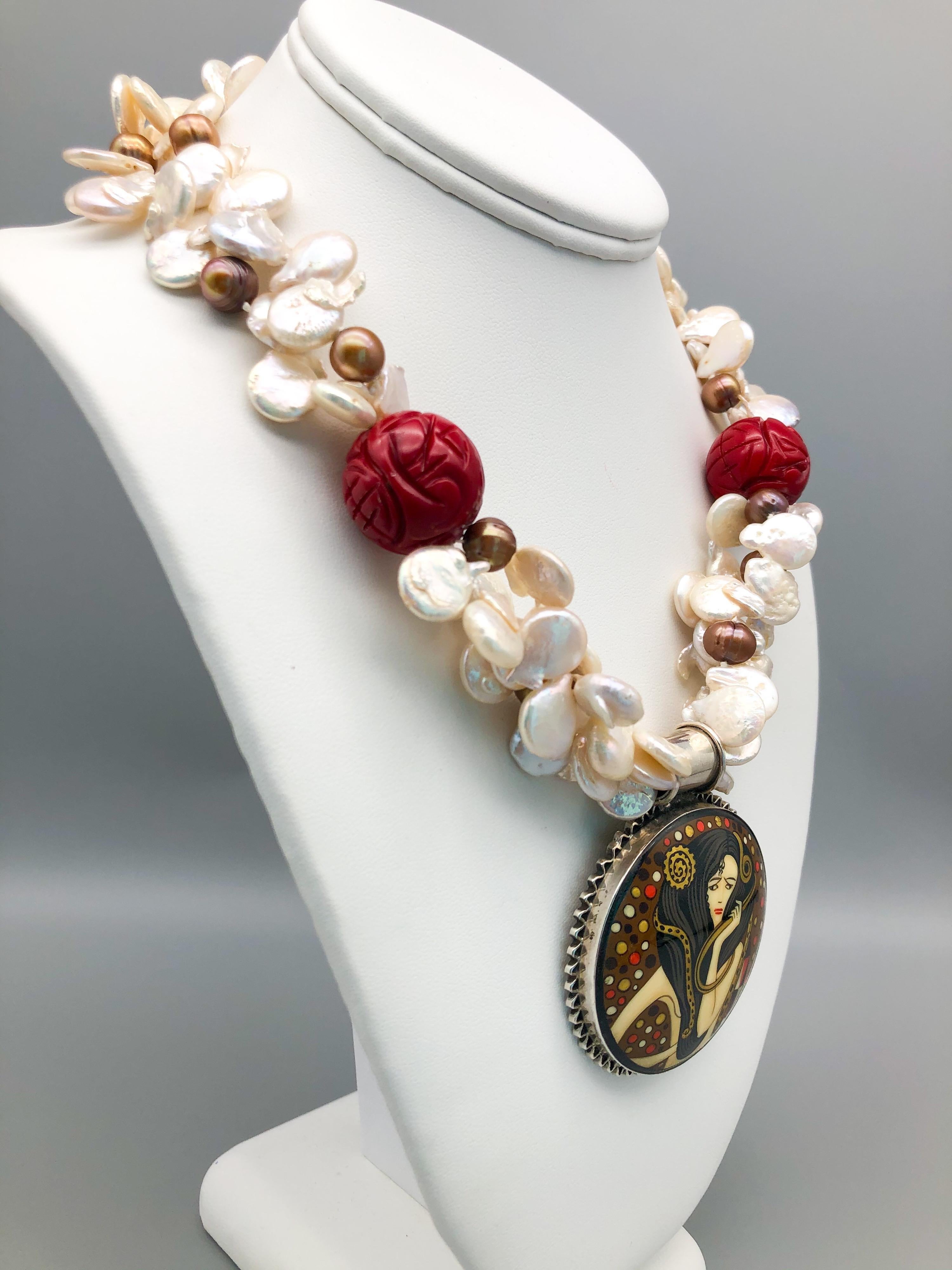 One-of-a-Kind
The pendant is hand-painted and signed on an onyx disc measuring a 2” circumference set in sterling silver. It hangs from a double strand of baroque pearls, punctuated by a pair of carved Chinese red double happiness beads. The clasp