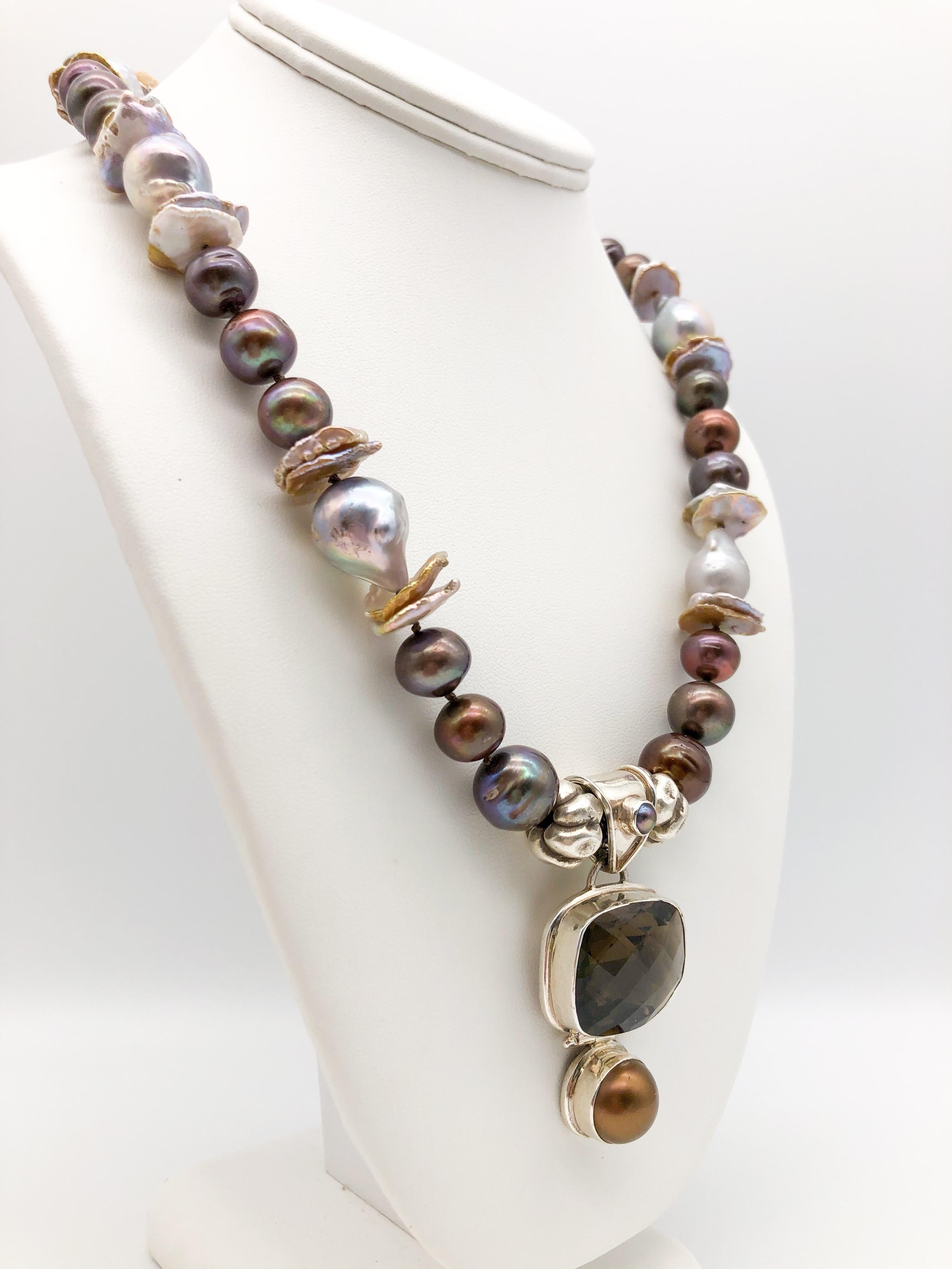 One-of-a-Kind

Dusty Smoky Quartz and chocolate pearl pendant hang from a mixed pearl necklace.
Soft silvery shades combine in a necklace of dark gray peals, dove gray baroque pearls and center drilled greige pearls. The necklace holds a pendant of