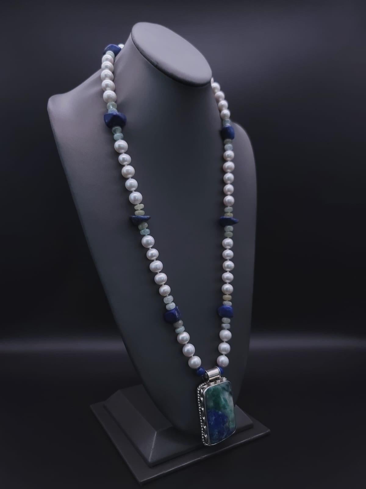 One-of-a-Kind

Long (36”) necklace anchored with a hard-to-find true blue and green Chrysocolla pendant set in sterling . The necklace is 10m.m freshwater pearls between natural polished lapis lazuli and aquamarine marine spacers mimicking the