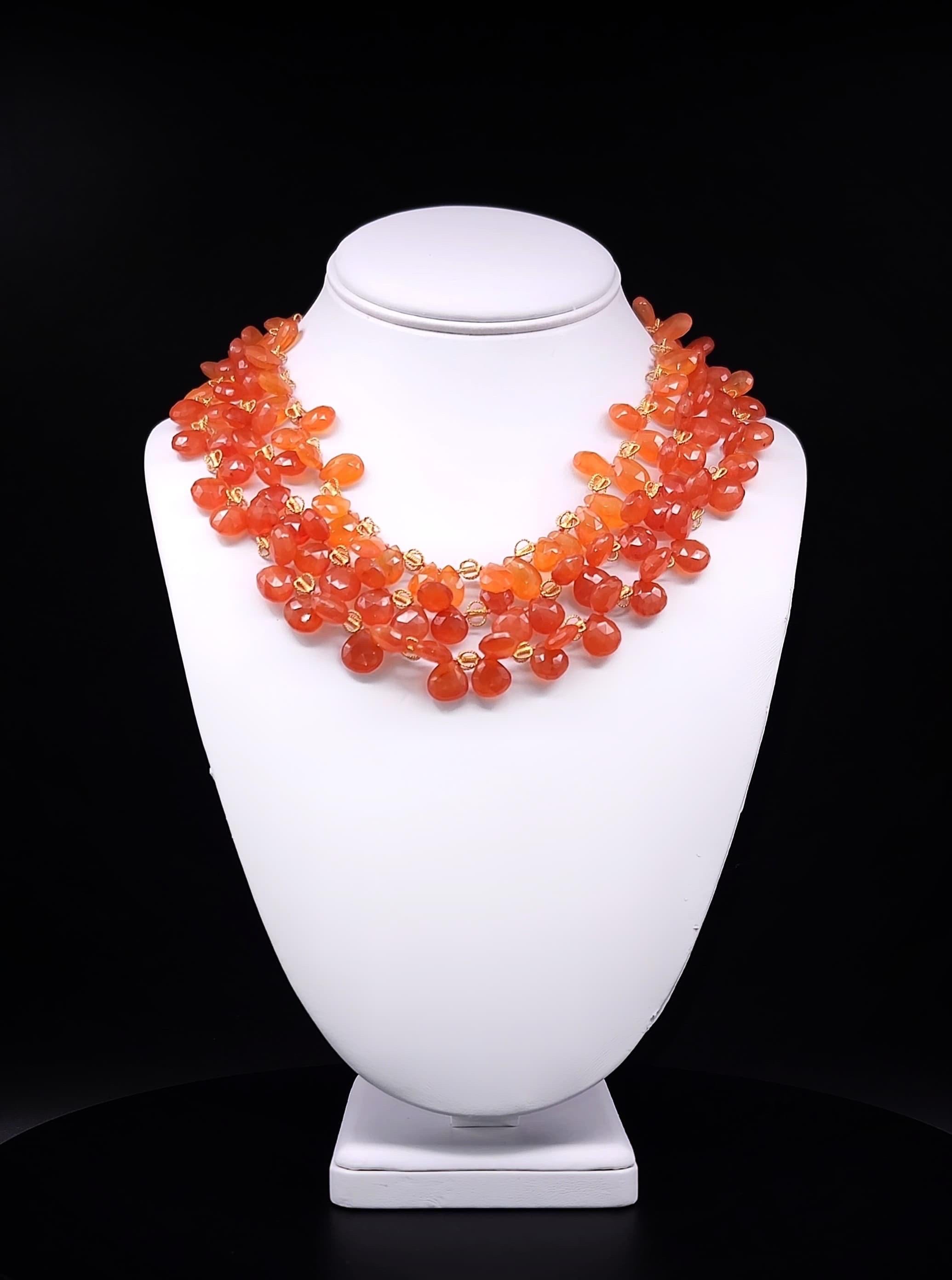 Envision possesses a unique adornment—a three-strand necklace featuring a graduated 17-inch to 18-inch arrangement of equally sized, stunning orange carnelian beads, each meticulously sourced from the vibrant landscapes of Brazil. These beads,