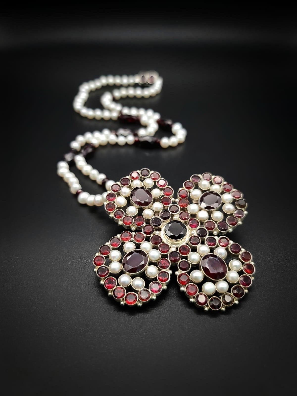 One-of-a-Kind

Stunning garnet and pearl cross (3”x 3”), each stone set in heavy Sterling Silver, serves as an anchor for a 27” necklace of 4-5 m.m Pearls interspersed between facetted Garnets. 
The clasp is 2 garnets set in silver.

The pomegranate