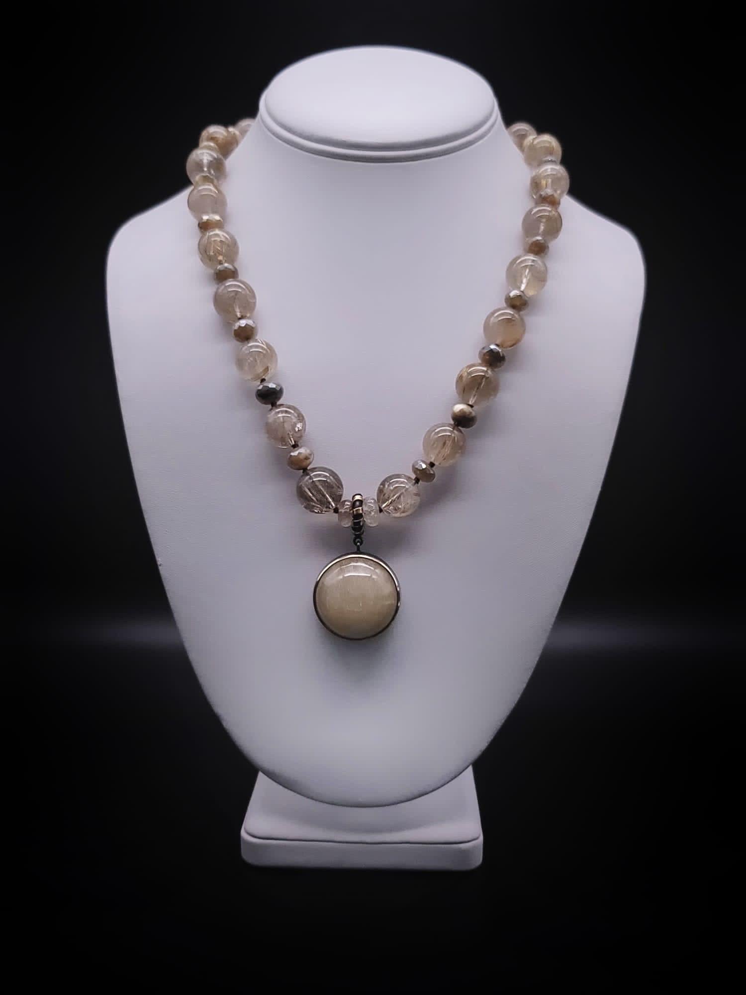 One-of-a-Kind

Golden rutilated quartz  16m.m. bead necklace surrounds a large shaped and polished  Rutile cabochon stone set in a brass pendant handcrafted by Bora. The Rutilated quartz beads with golden rutile running through the stone. No two