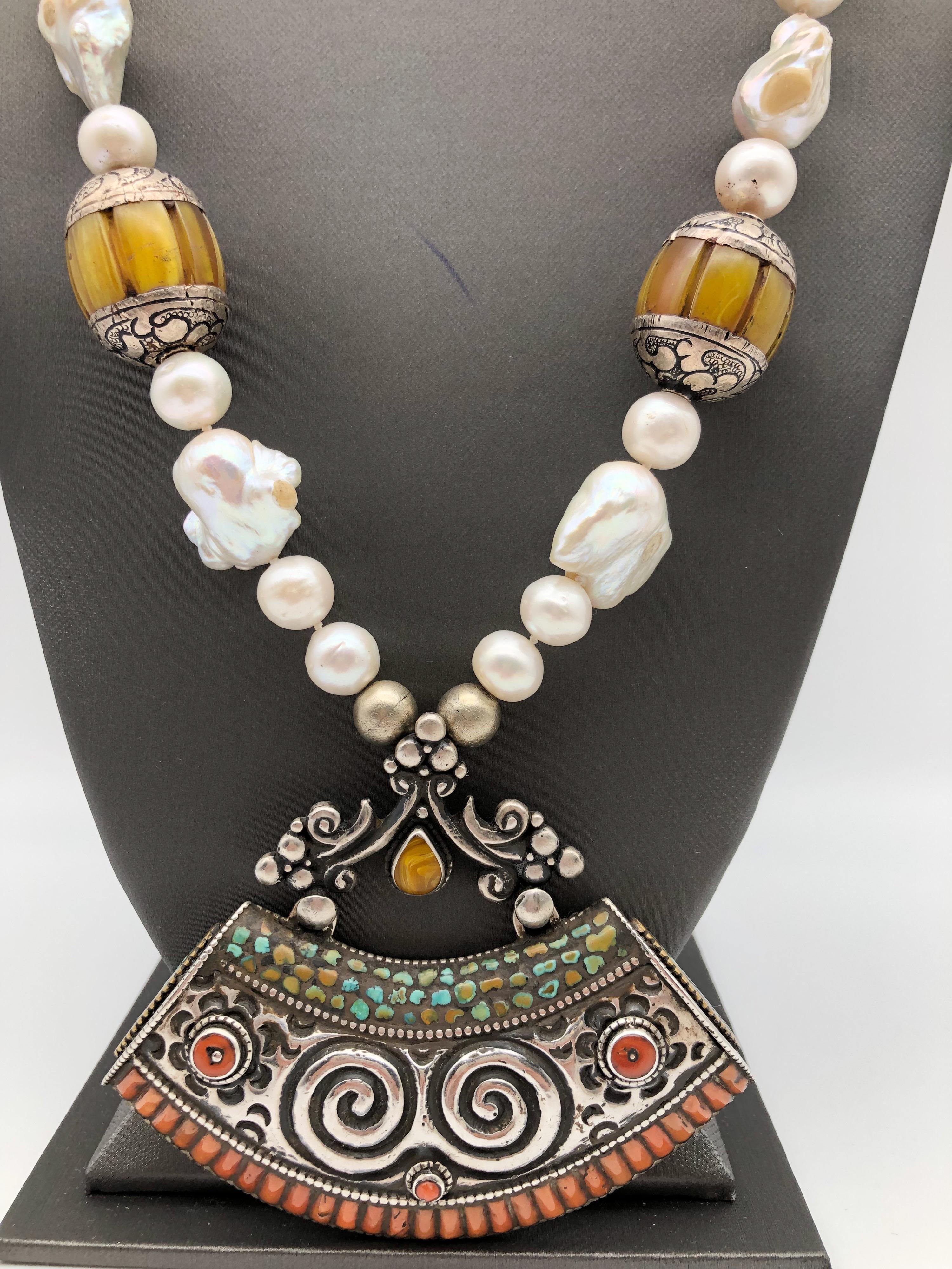 One-of-a-Kind
Ethnic Beads with Tibetan Sterling Silver carved Pendant
Freshwater Pearls 12-14mm, Baroque Pearls, assorted Turquoise, and Tibetan beads.
Sterling Silver pendant size 4' X 2', reverse side of the pendant has detailed 