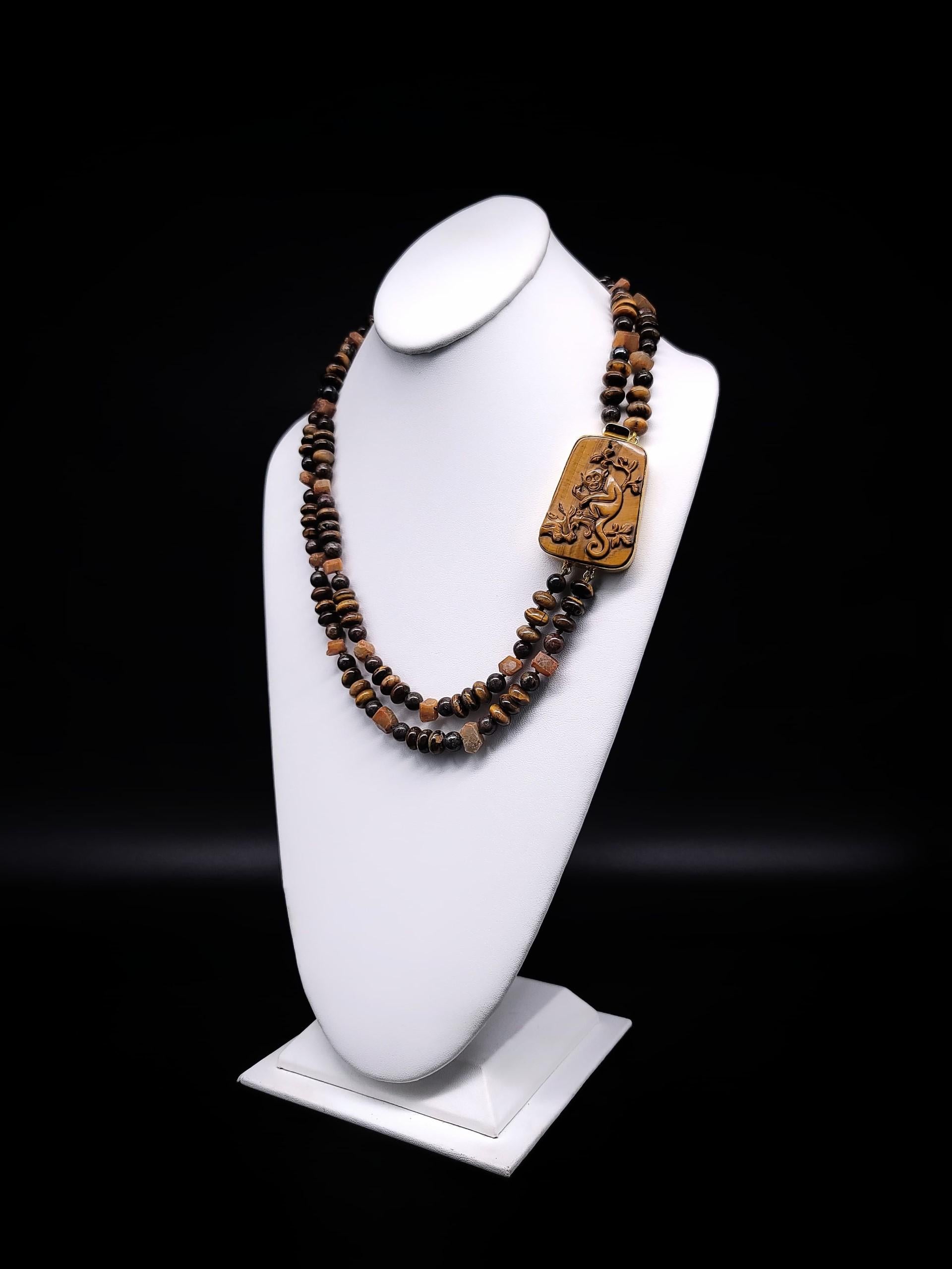 Élevez votre style avec ce collier à deux brins unique en son genre, qui présente un mélange harmonieux d'œil de tigre et de saphirs jaunes exquis de Madagascar. Cette pièce se distingue non seulement par ses magnifiques pierres précieuses, mais