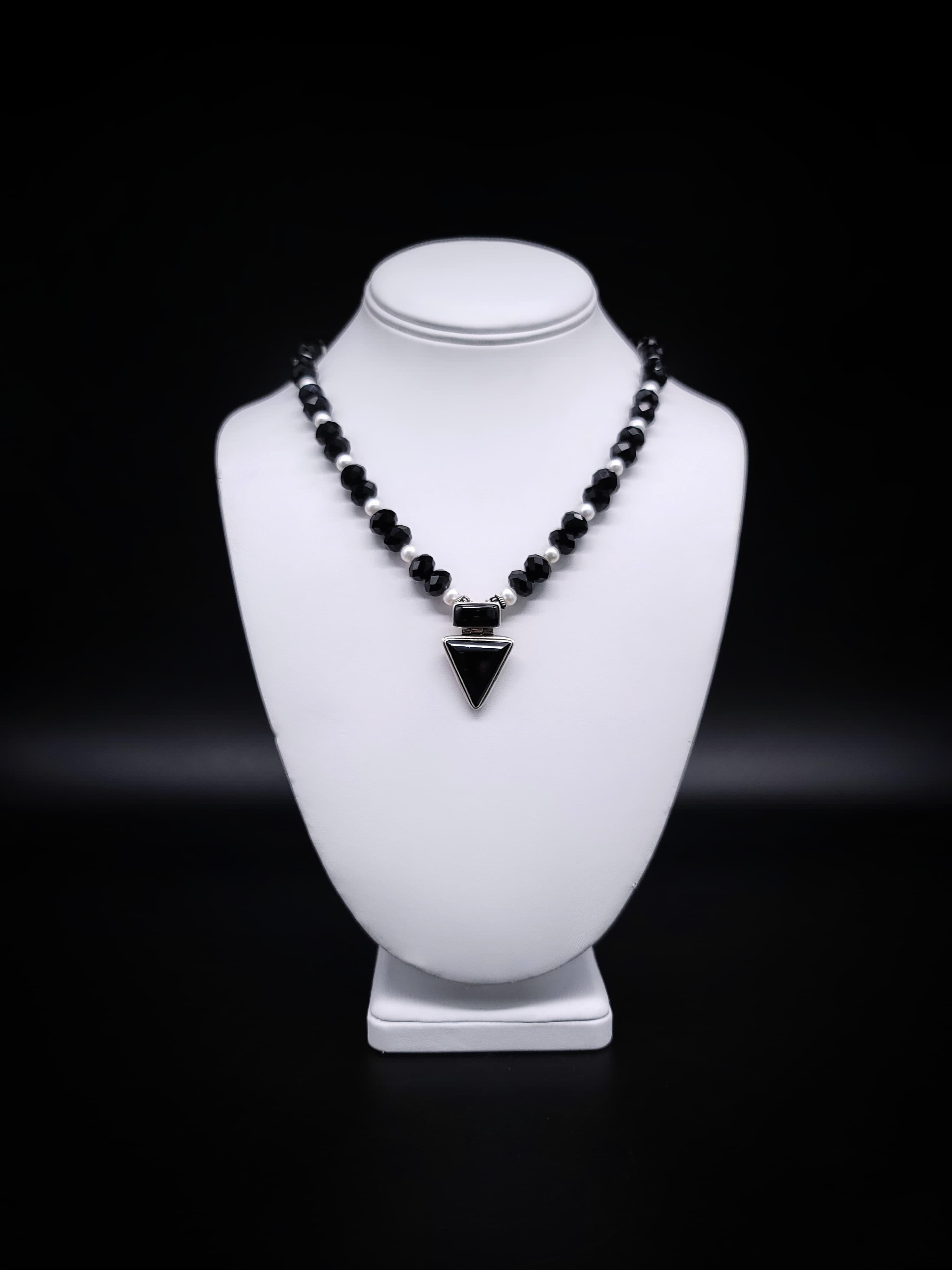 One-of-a-Kind

Introducing a uniquely captivating unisex necklace featuring faceted onyx beads, adorned with freshwater pearl spacers, and crowned by an inverted triangular onyx pendant, all set in sterling silver.
The necklace begins with a