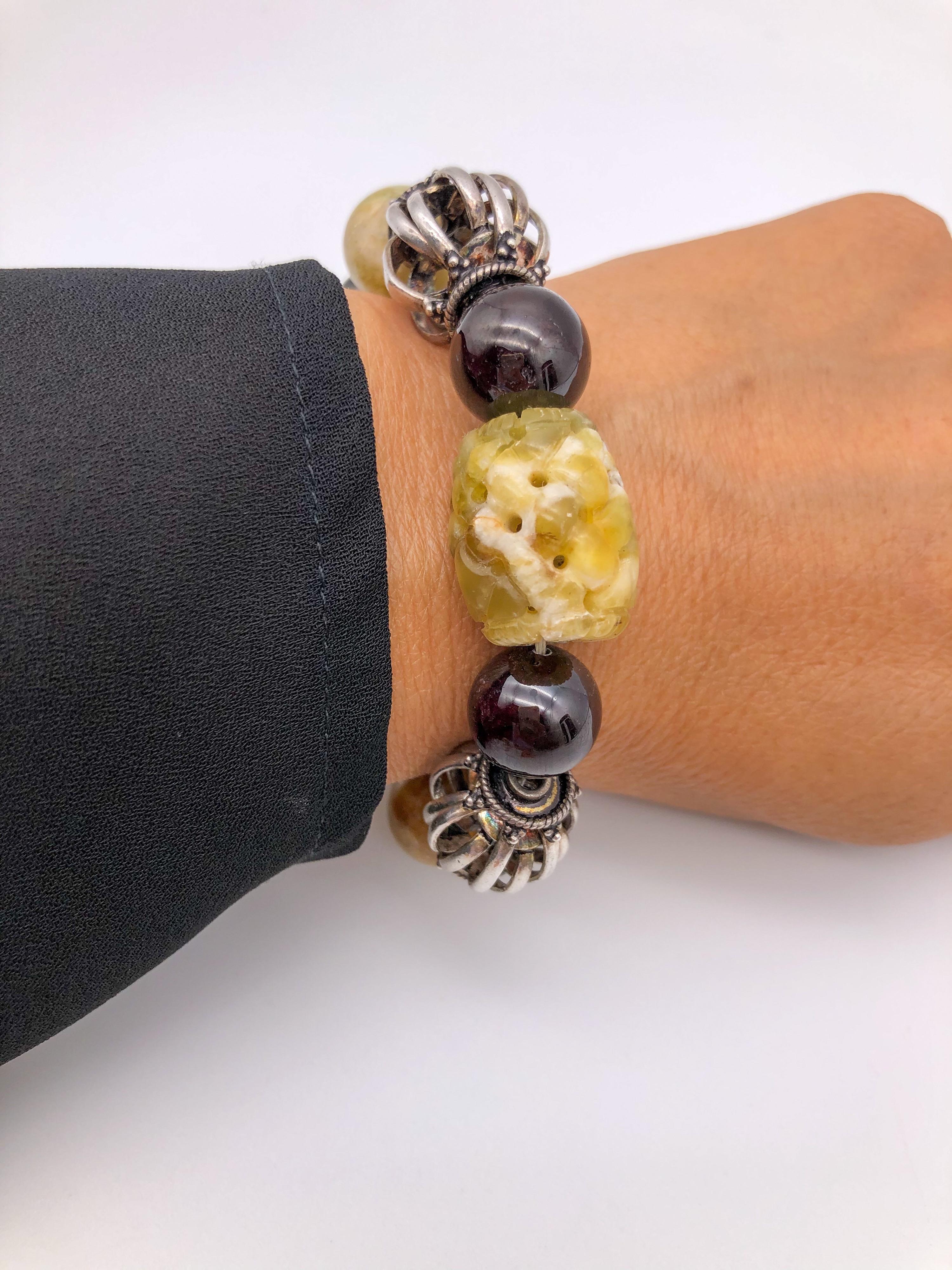 One-of-a-Kind
 Signature bracelet two gemstone, Yellow Jade polished/carved beads with brilliant graduated Garnet.
 Sterling Silver beads, The clasp is a little Sterling Silver box.
One obvious meaning of the jade stone is purity or purification.