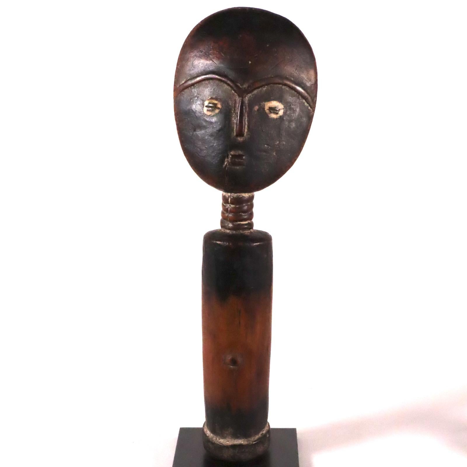 An old and obviously well used akuaba or fertility doll from the Akan people of Ghana, early 20th century. Wood with remains of white pigments, oily patina from ritual feeding, washing, and oiling. Since it was once clothed, the mid-section is