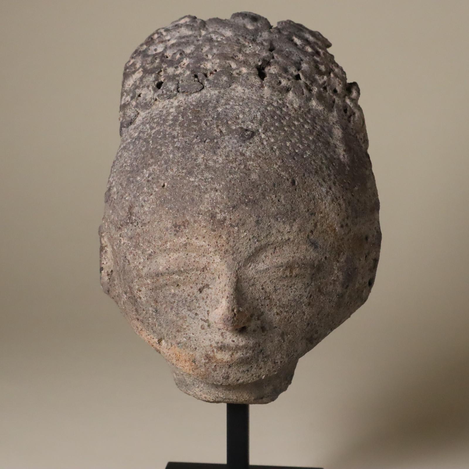 Store closing March 31. This is an earthenware or terracotta portrait from the Akan people of Ghana. 19th century or earlier. 
This has a Buddha-like expression of contemplation and peace. The facial features are small delicate. A little little