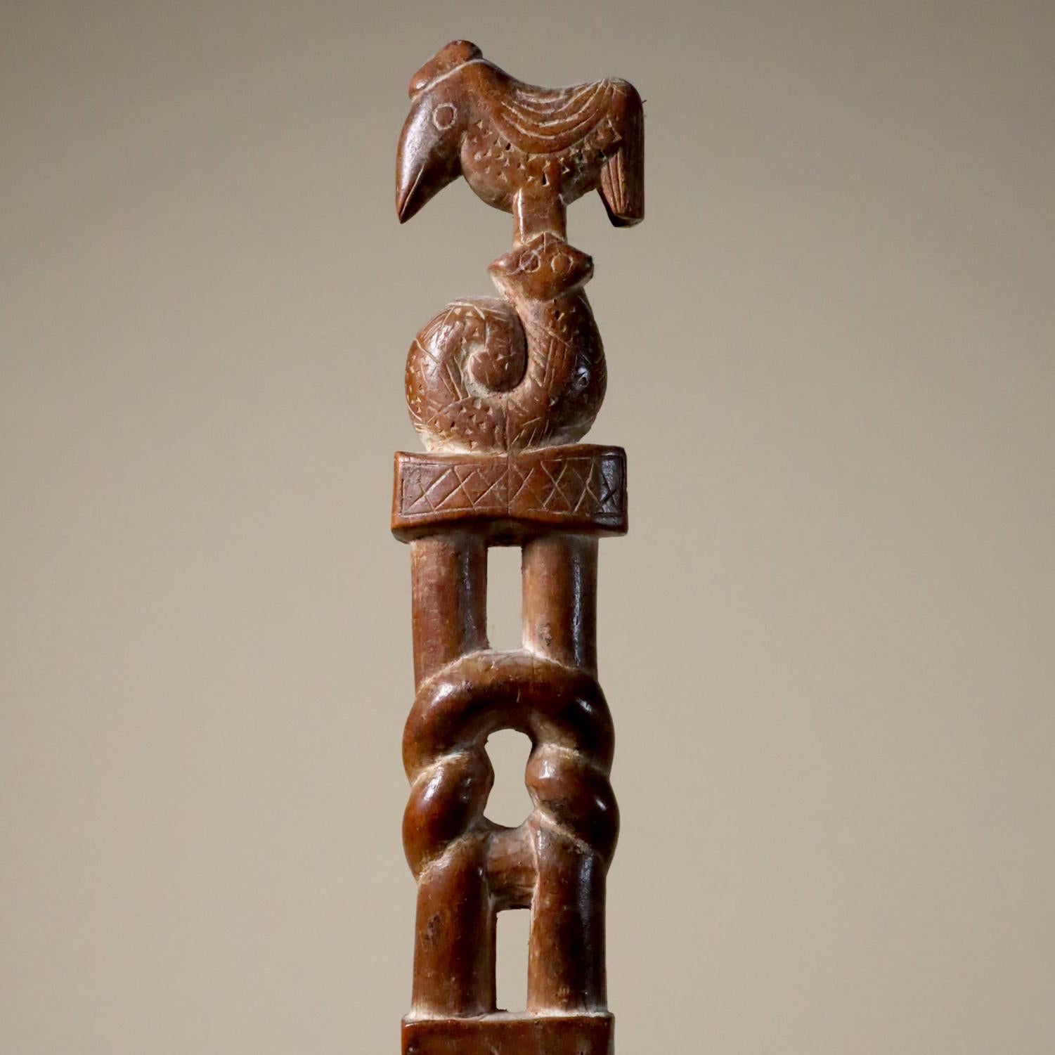 A finely carved Akan ceremonial wand or staff, Ghana, 20th century. Hardwood a lovely brown color with a high polish. White pigments are rubbed into incised lines, notches and crevices. The animals, double-blade sword, hearts, and knot are all