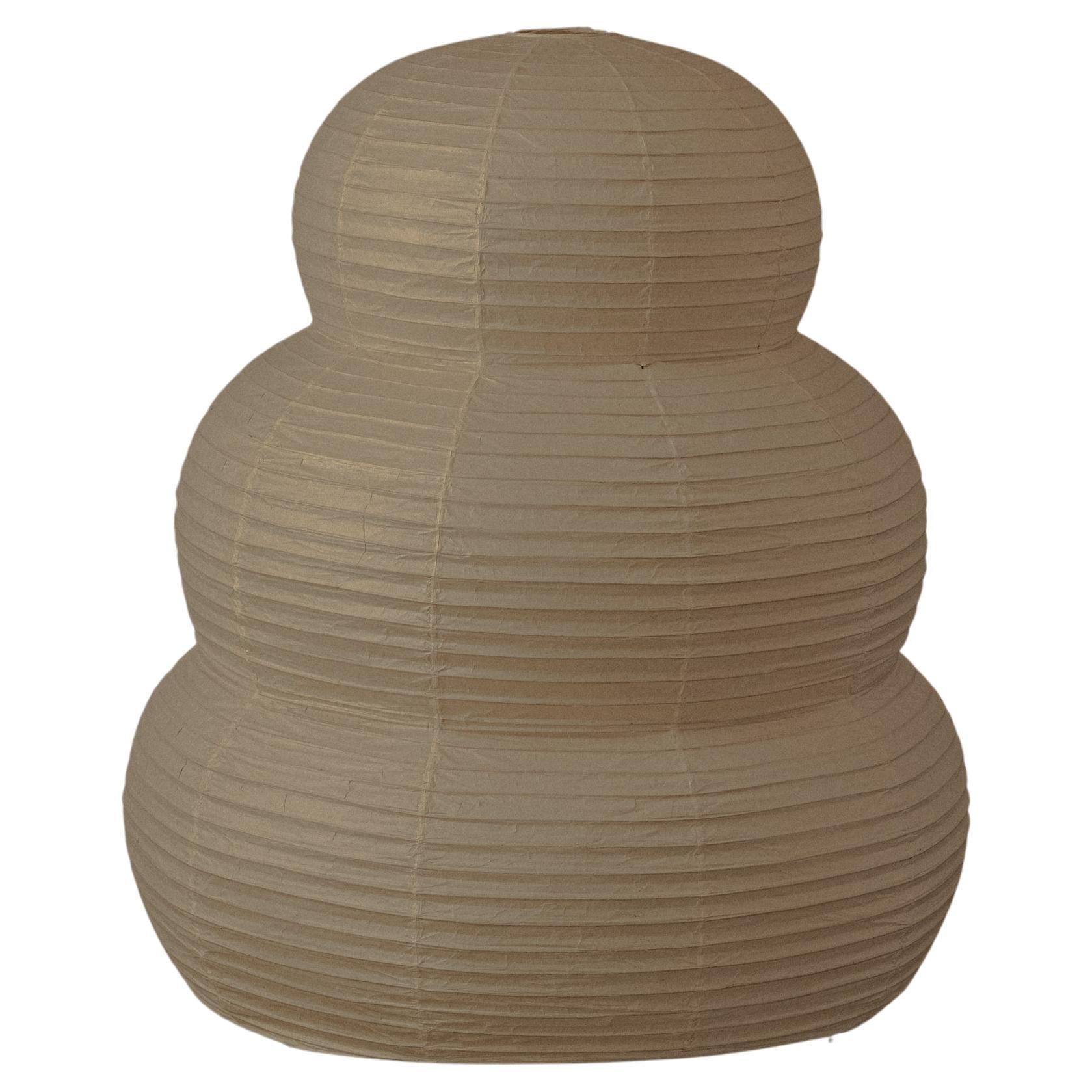 Lampada da terra Akari 31N di Isamu NoguchiLa lampada da terra Akari 31N di Isamu Noguchi degli anni '50 fa parte della serie Akari Light Sculptures. Presenta un paralume in carta washi a tre livelli su una struttura in bambù con gambe in metallo.