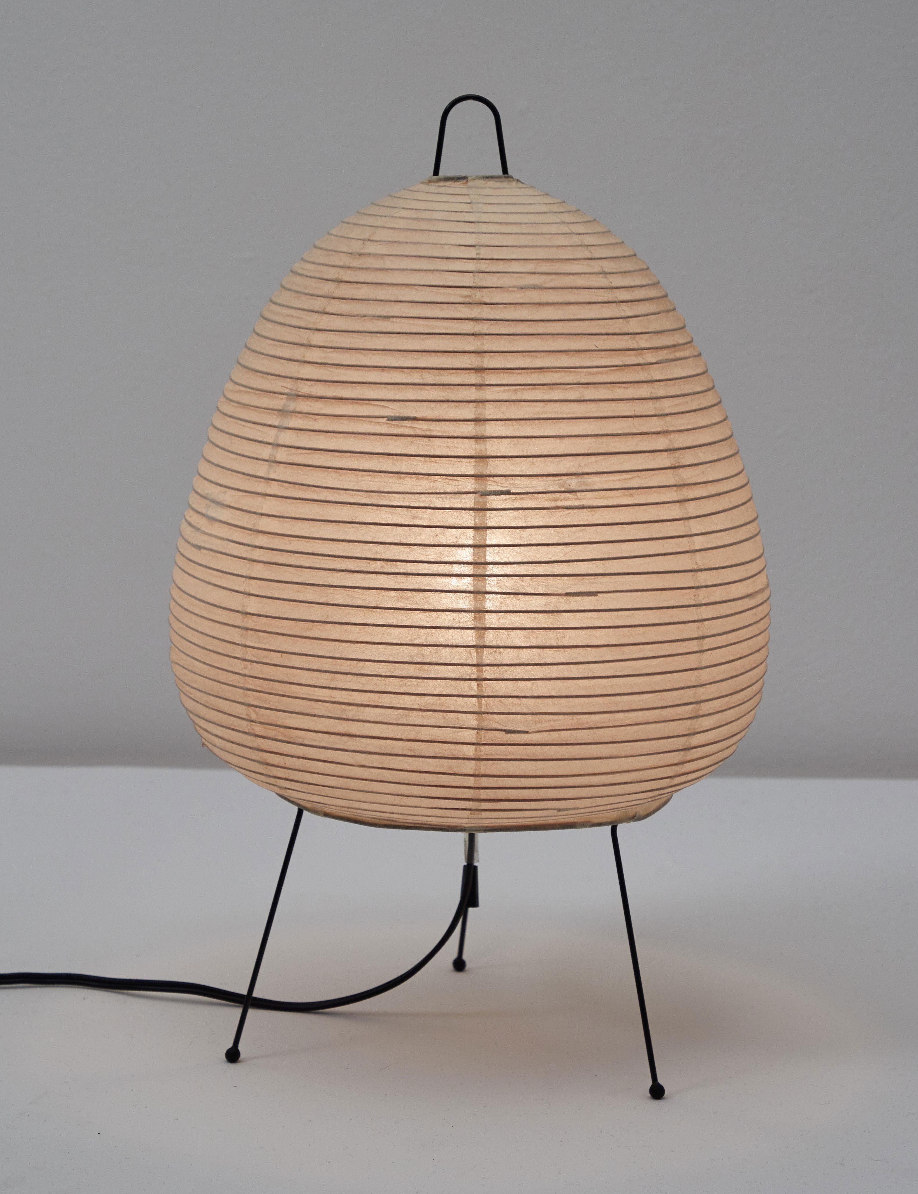 Original first production Akari model 1A light sculpture by Isamu Noguchi. Designed and manufactured in Japan, circa 1950s. Rice paper and enameled metal. Retains original sun/moon stamp. Comes with original box and literature and includes one