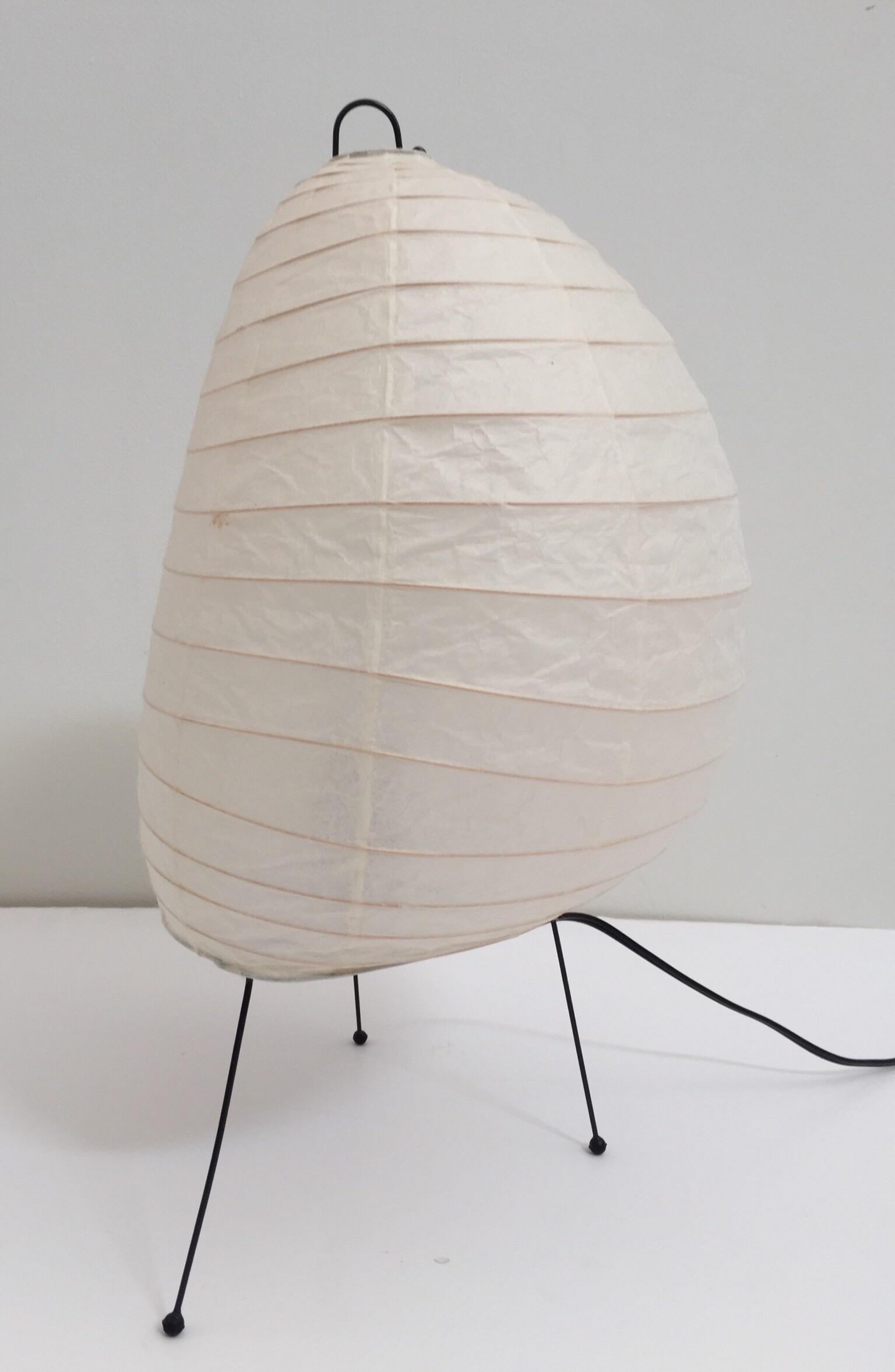Vintage Akari lamp designed by Isamu Noguchi. 
The timeless Akari light sculpture by Isamu Noguchi design provides a sculptural form as well as a warm glowing source of light.
The shade is made from handmade washi paper and bamboo ribbing
