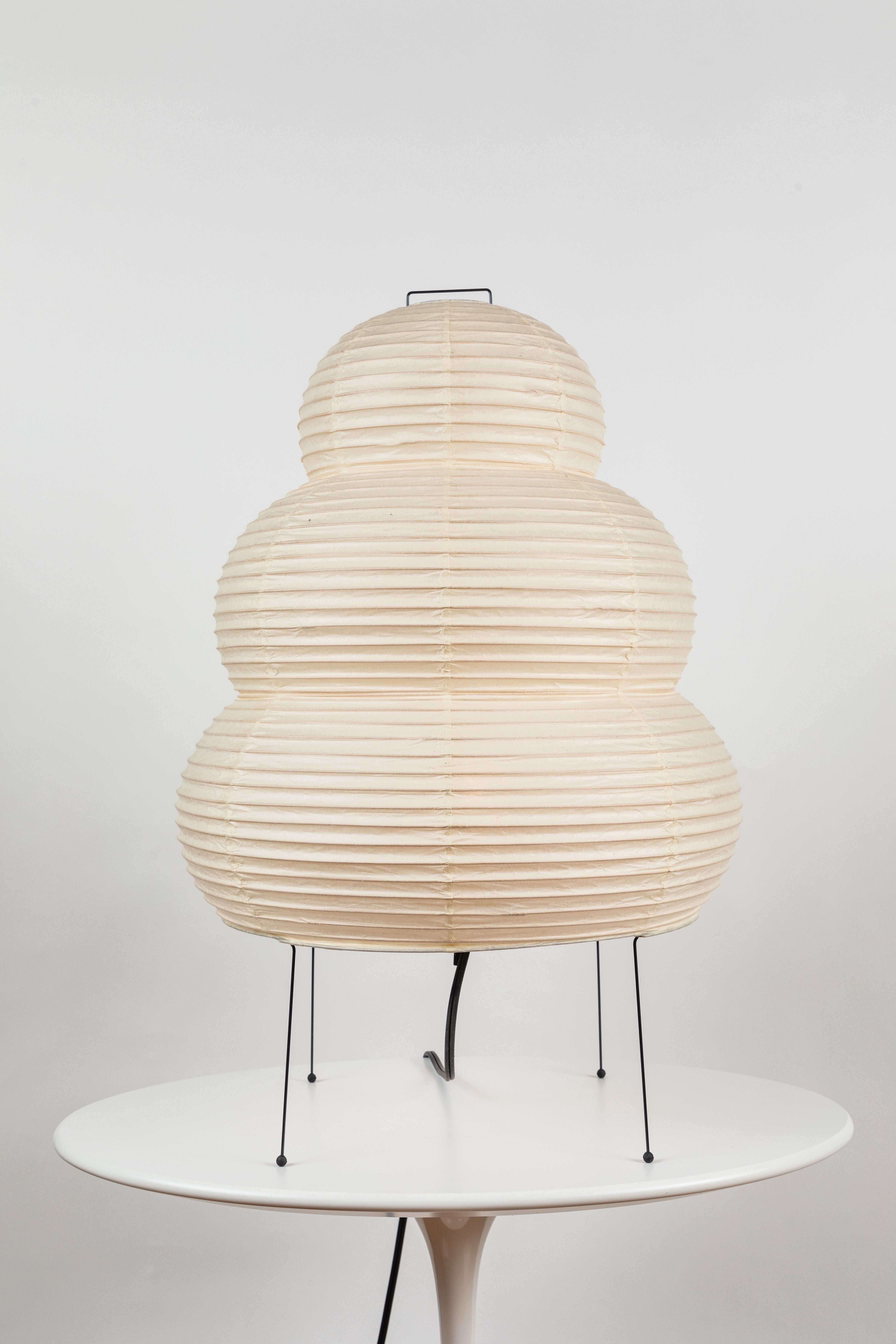 Akari model 20N light sculpture by Isamu Noguchi. The shade is made from handmade washi paper and bamboo ribs with Noguchi Akari manufacturer's stamp. Akari light sculptures by Isamu Noguchi are considered icons of 1950s modern design. Designed by