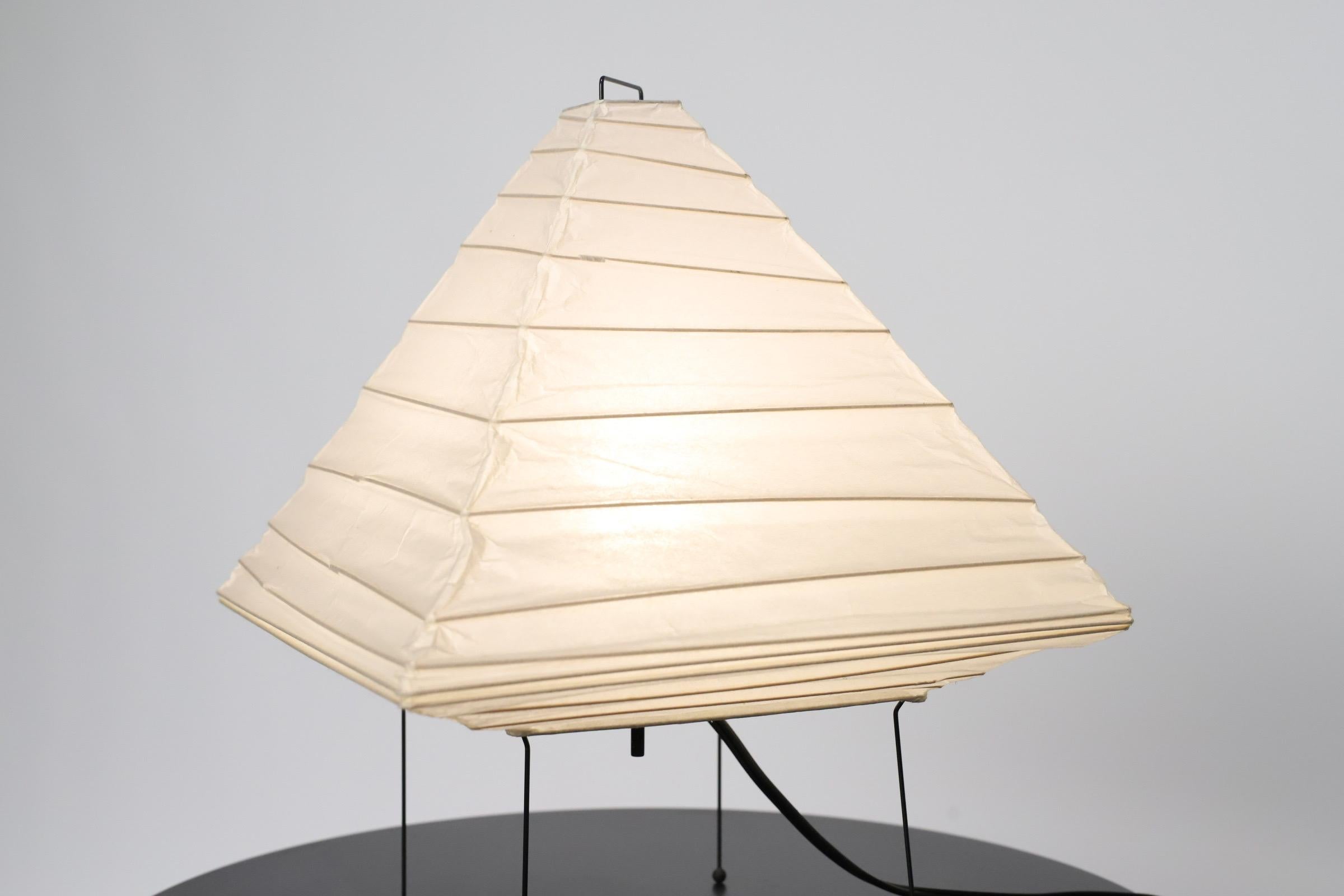 Akari Model 5x light sculpture by Isamu Noguchi. The shade is made from handmade washi paper and bamboo ribs with Noguchi Akari manufacturer's stamp. Akari light sculptures by Isamu Noguchi are considered icons of 1950s modern design. Designed by