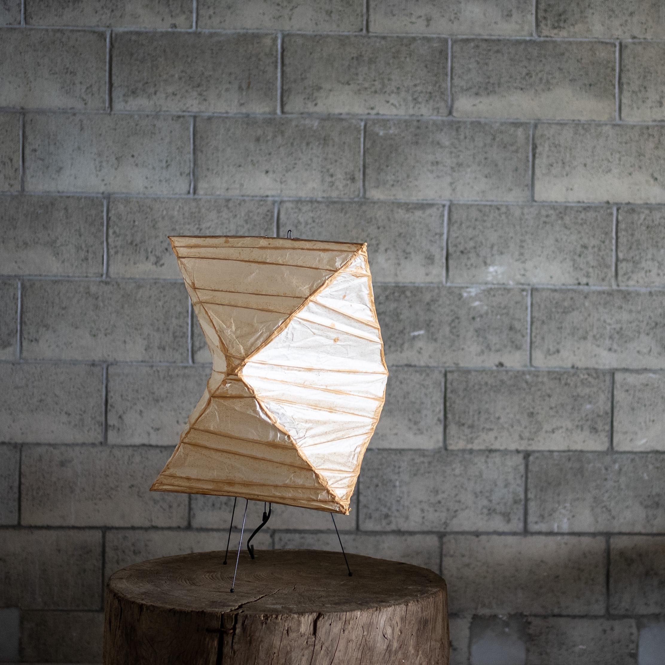 An original Akari light sculpture by Isamu Noguchi, crafted in Japan with washi paper on a delicate wire frame. This iconic series combine organic warmth with sculptural geometry, creating a soft, atmospheric glow.

The present example features a