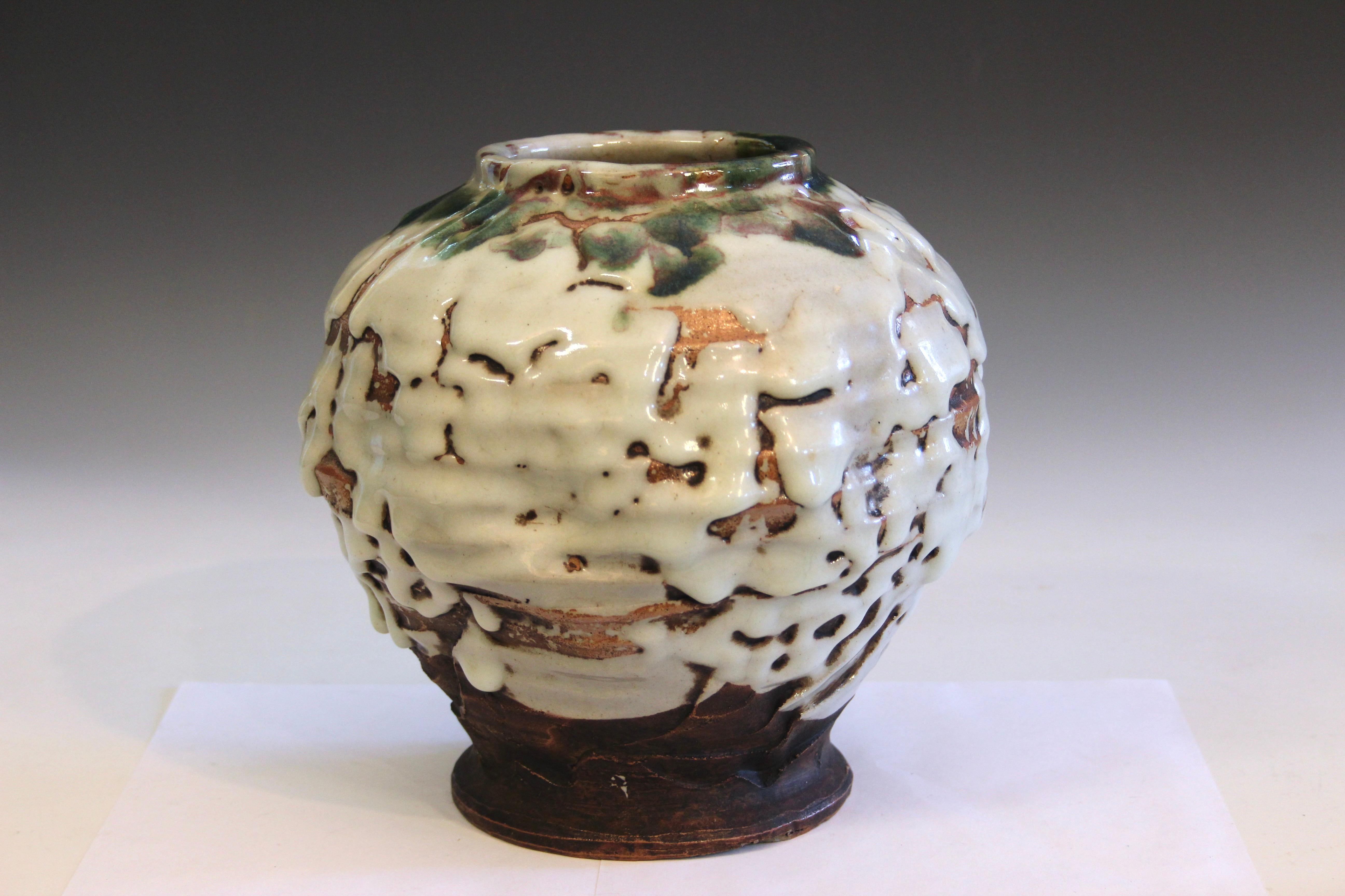 This Akashi-Awaji pottery vase, dating to circa 1930, exemplifies the modernist direction and innovative glaze work characteristic of late Awaji ware, particularly after the Sanpei kiln’s relocation to the mainland city of Akashi. The piece is