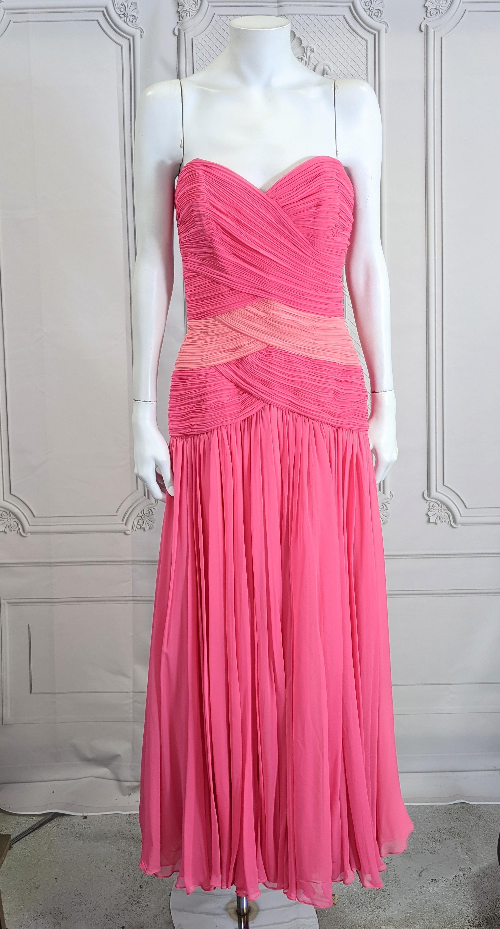 Glamorous Akira Silk Chiffon Draped Gown with a tight torso which opens to a super full layered chiffon skirt. Corset construction with hot and pale pink silk chiffon hand pleated and tacked onto strapless base with zipper entry, attached to a full