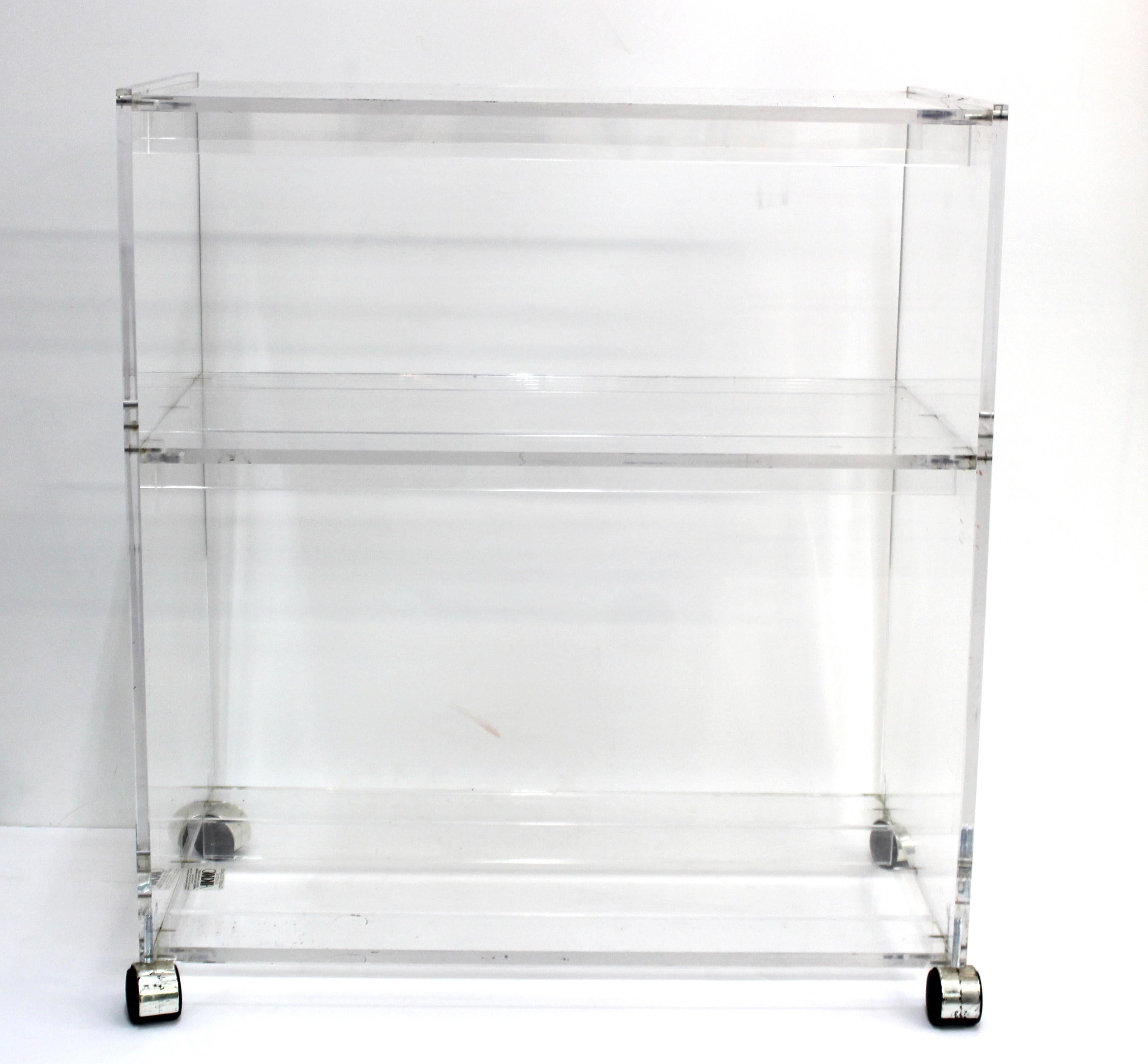 Modern acrylic serving cart or bar cart, made by AKKO in Massachusetts during the late 20th century. The piece has three storage levels and is in great vintage condition with some age-appropriate surface wear to the acrylic.