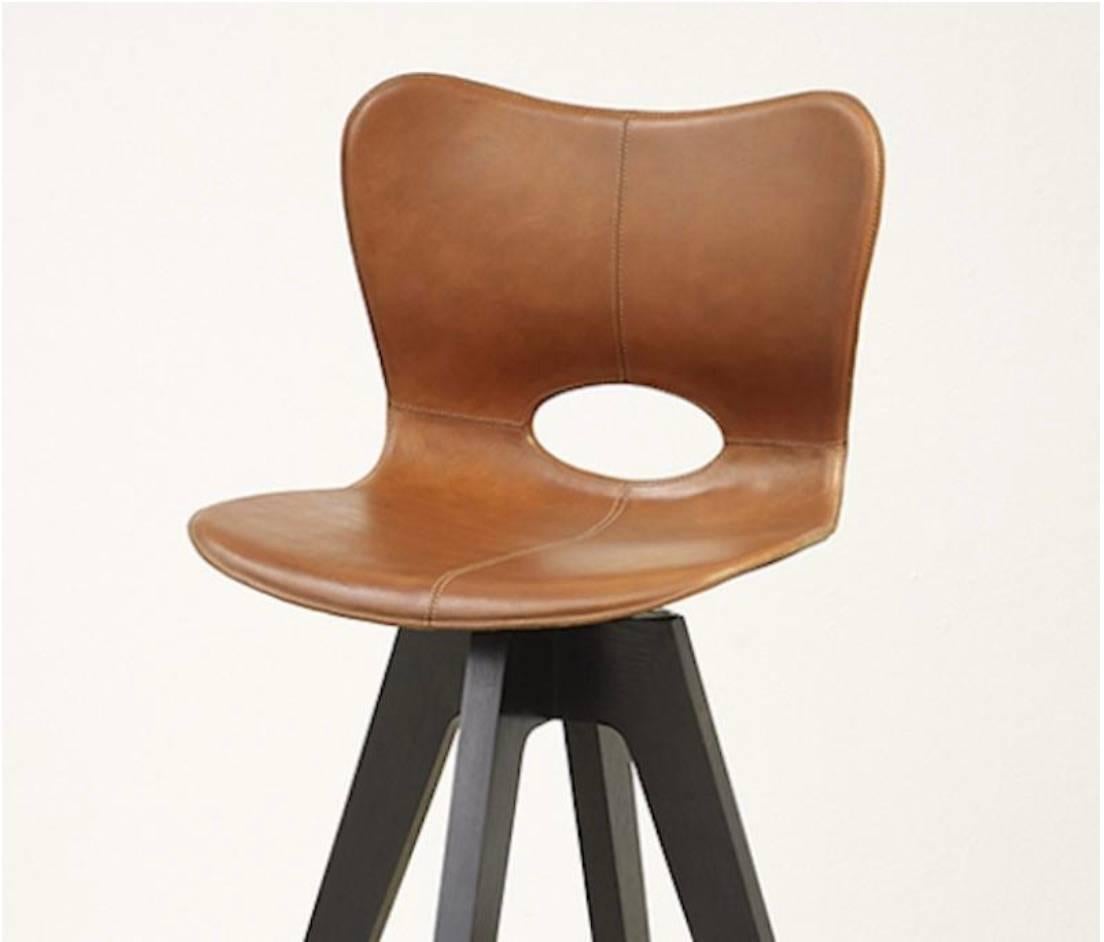 The AKMD collection Lariat barstool is hand-stitched by traditional saddle makers in North India. The seat is top-grain saddle leather and the hardwood base is available in espresso brown or light brown from the fabricators located in the Humboldt