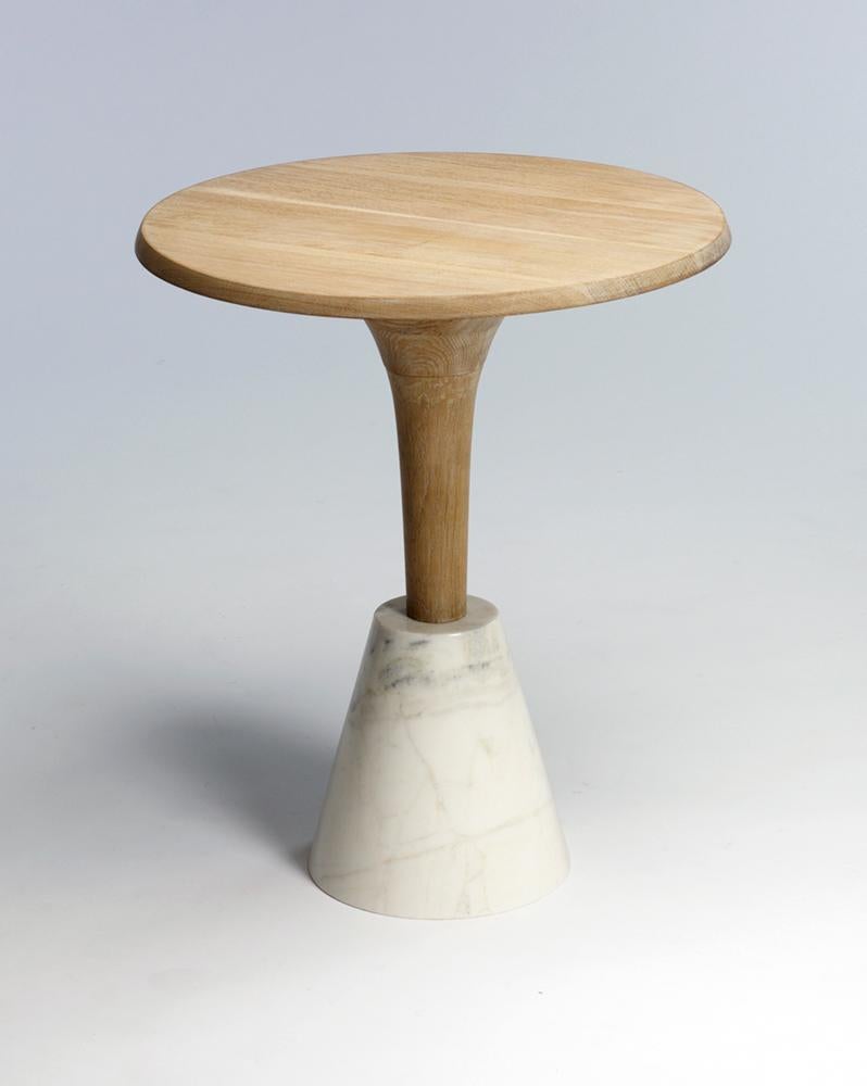 Cette table d'appoint d'influence scandinave est disponible en chêne blanc avec une base en marbre blanc pourpre. 

Le plateau et le fuseau en chêne sont tournés à la main après avoir été assemblés. Le socle en marbre est sculpté à la main dans du