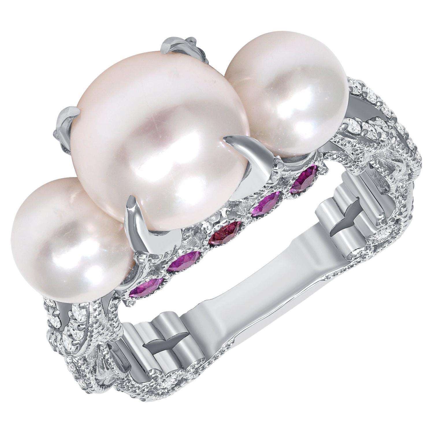 Designed by award-winning artist Brenda Smith, this size 7 Akoya cultured pearl ring has one 9-millimeter pearl and two 6-millimeter pearls hand cast and finished in 18-karat white gold. It also has 0.44 carats of hot pink sapphires on its sides and
