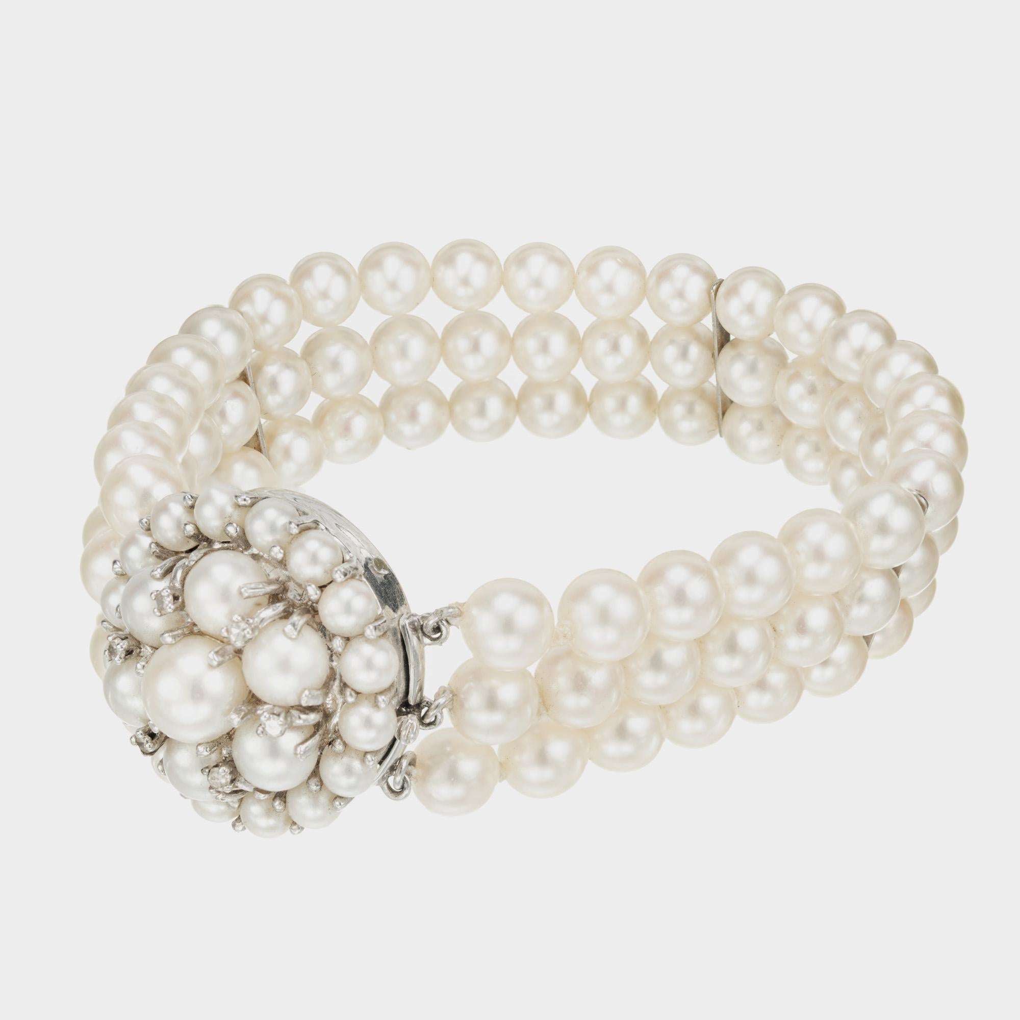 Bracelet multibrins en perles et diamants. 3 rangs de perles de culture Akoya séparés par 3 séparateurs en or blanc 14k. Le loquet en forme de dôme est serti de perles de culture et de perles de verre  diamants blancs. 7 pouces de longueur. 

6