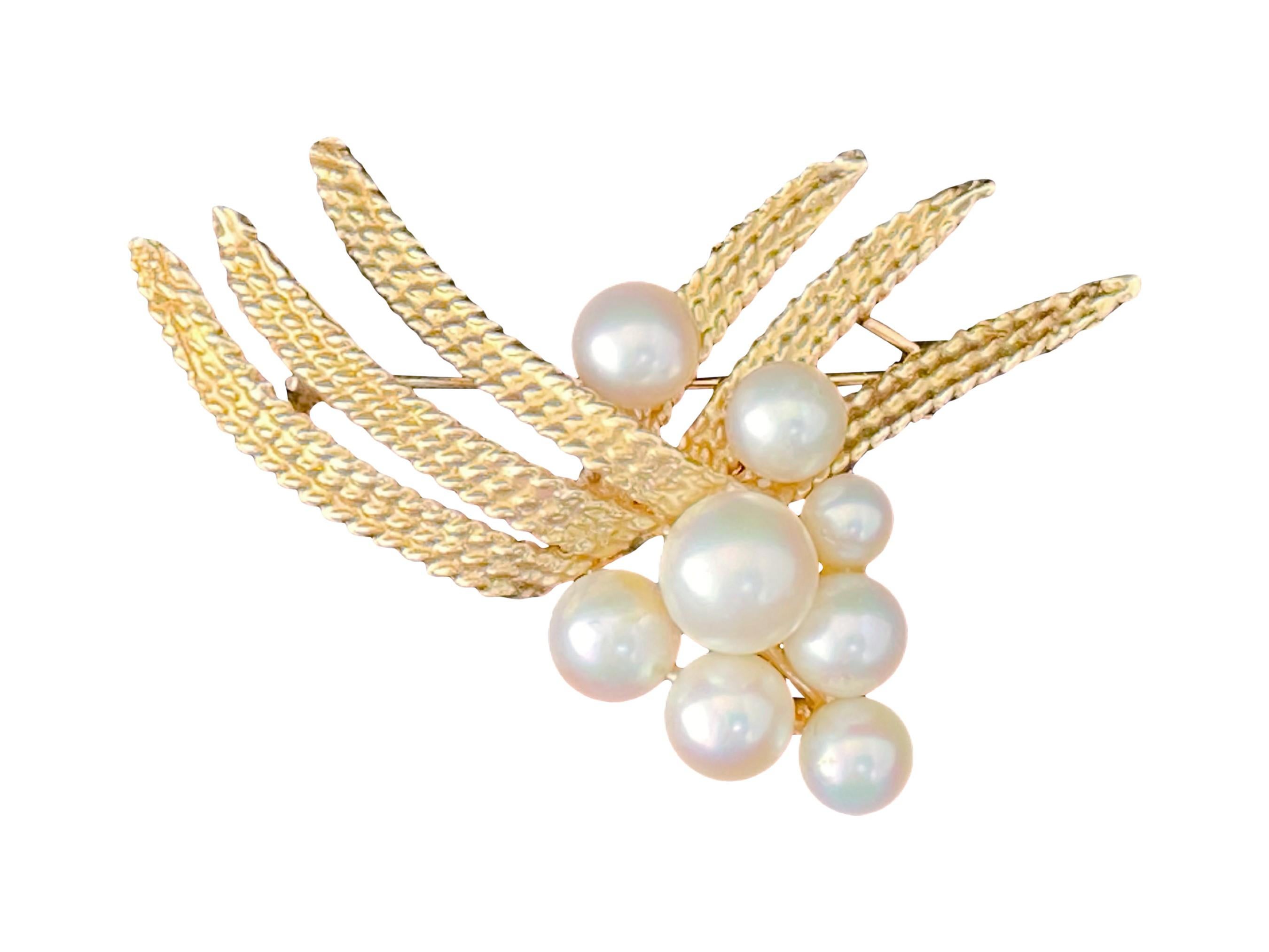 Gorgeous vintage 1970s solid 14k yellow gold pearl brooch. The brooch is composed of 8 saltwater Akoya pearls with good luster, varying from 4.5mm to 7.0mm in diameter. The pearls are clustered on 14k yellow gold in a foliate or wheat design.

The