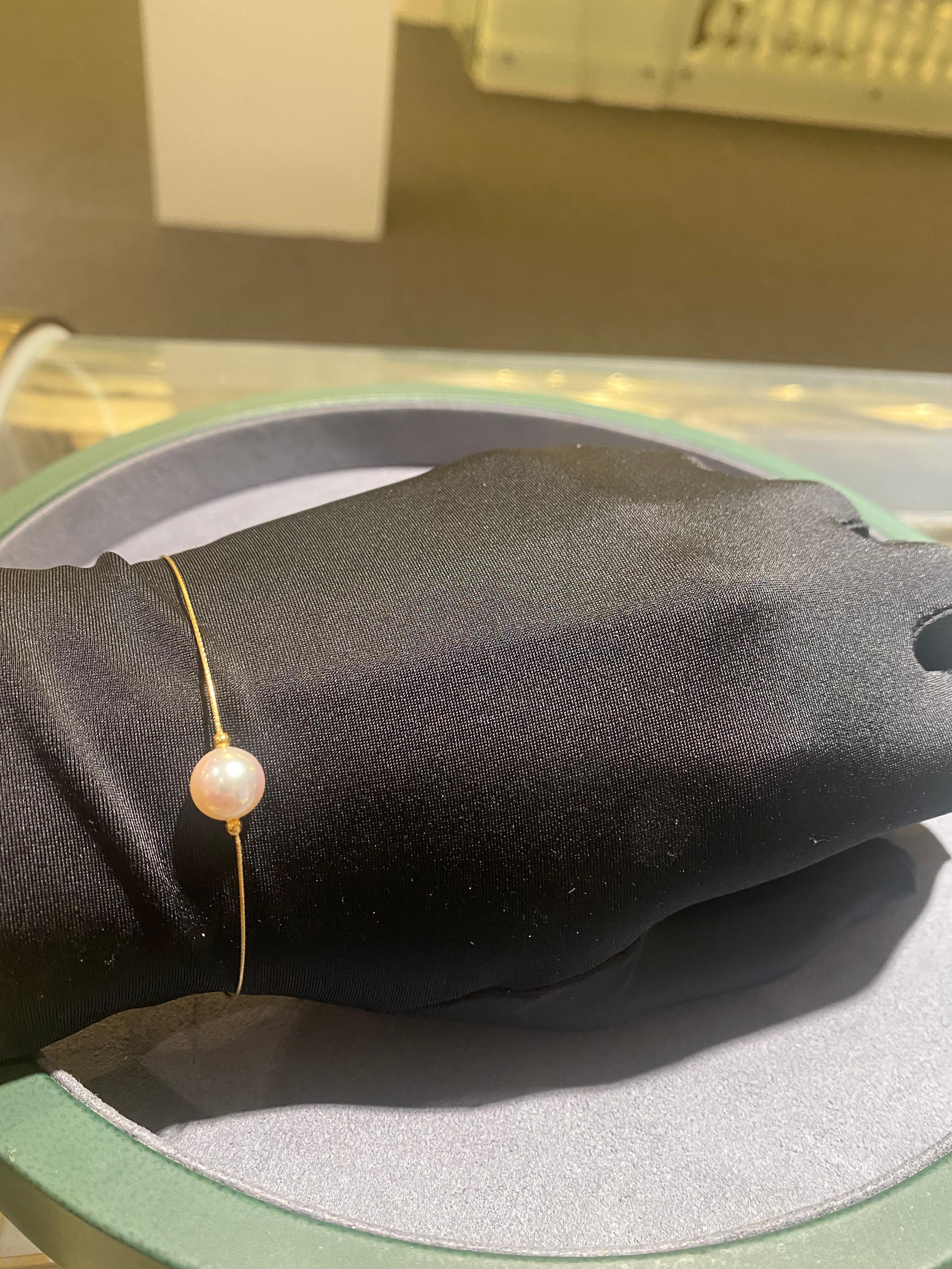 Un bracelet en or jaune 18k avec une perle Akoya de 8,7 mm fixée au milieu. La longueur du bracelet est réglable grâce à la chaîne attachée au bracelet.

La perle d'Akoya est de couleur blanche avec des nuances de rose, la surface de la perle est