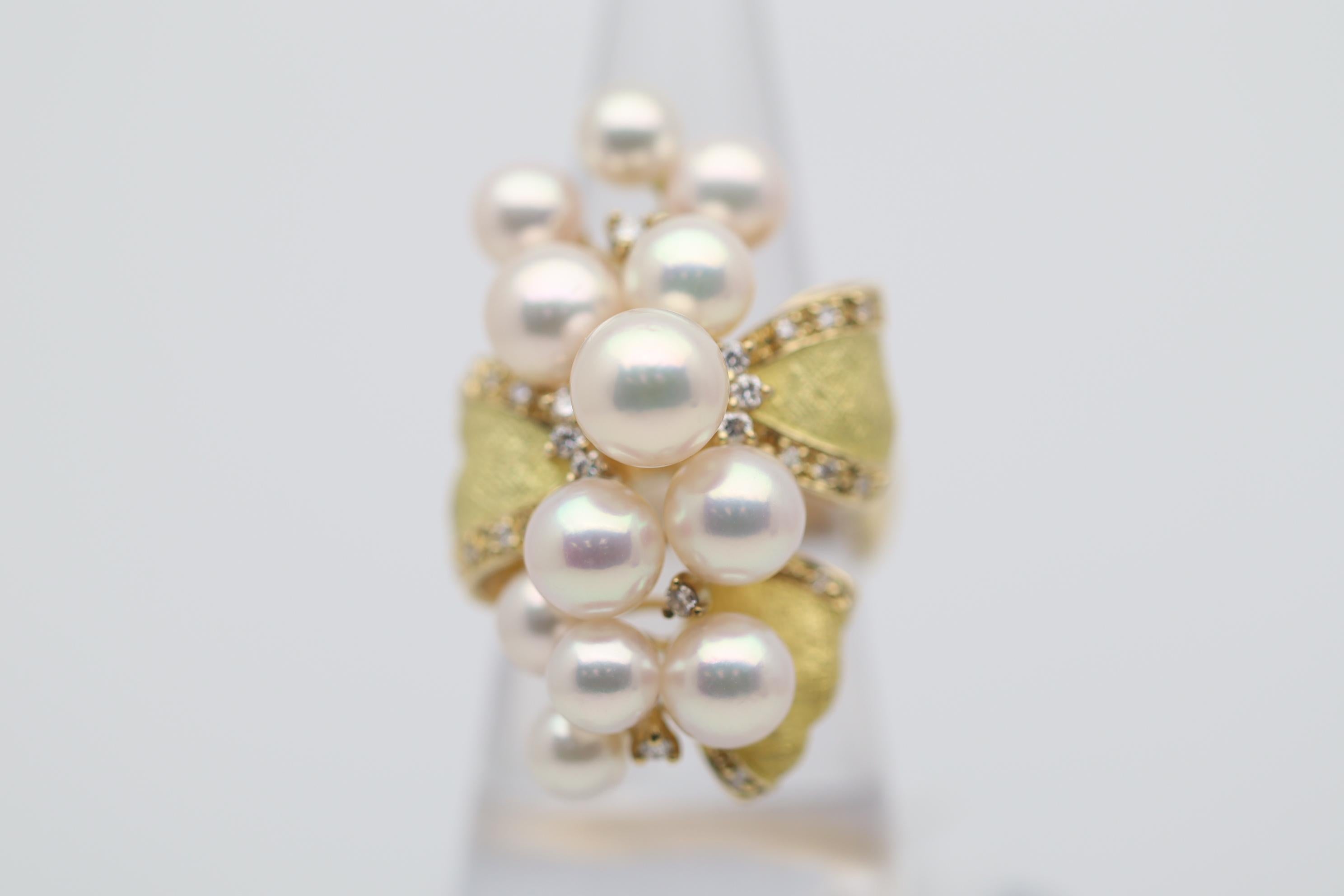 A large 18k gold cocktail ring studded with diamonds and a cluster of twelve AAA-Quality Akoya pearls. The pearls measure 5 - 8 millimeters in diameter and are all perfectly round with amazing luster and a strong pink/rose overtone that make the