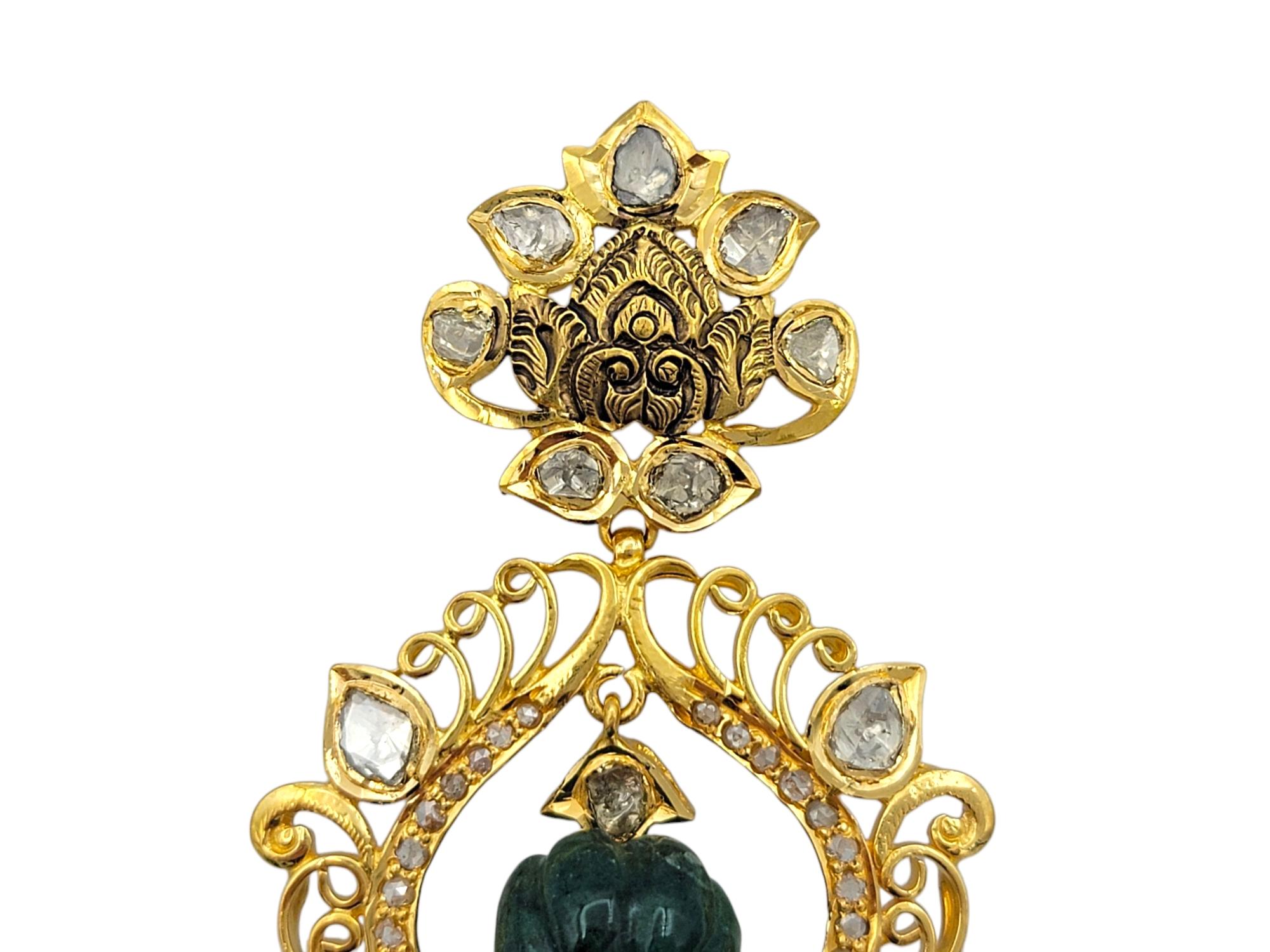 Lussuosi e intricati, questi orecchini lampadario emanano un'eleganza regale grazie all'opulenta miscela di pietre preziose e al design ornato. Realizzato in ricco oro giallo 22 carati, ogni orecchino è incentrato su uno smeraldo intagliato di