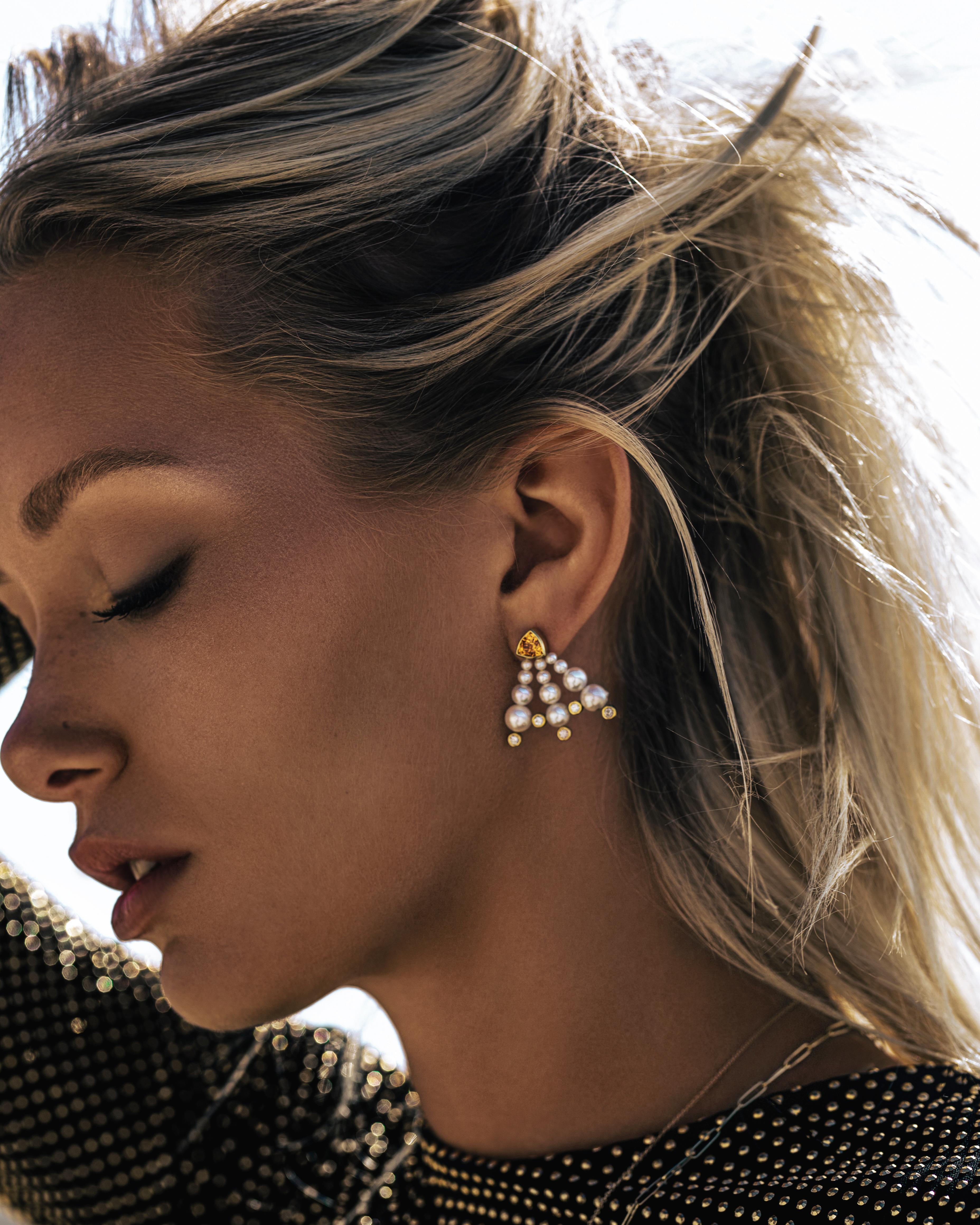 Perle Akoya graduate e diamanti incastonati emanano da due granati mandarini taglio trilione per creare un paio di orecchini eleganti e ariosi.   

La stilista si è inizialmente procurata questi due luminosi granati mandarini e ha cercato di pensare