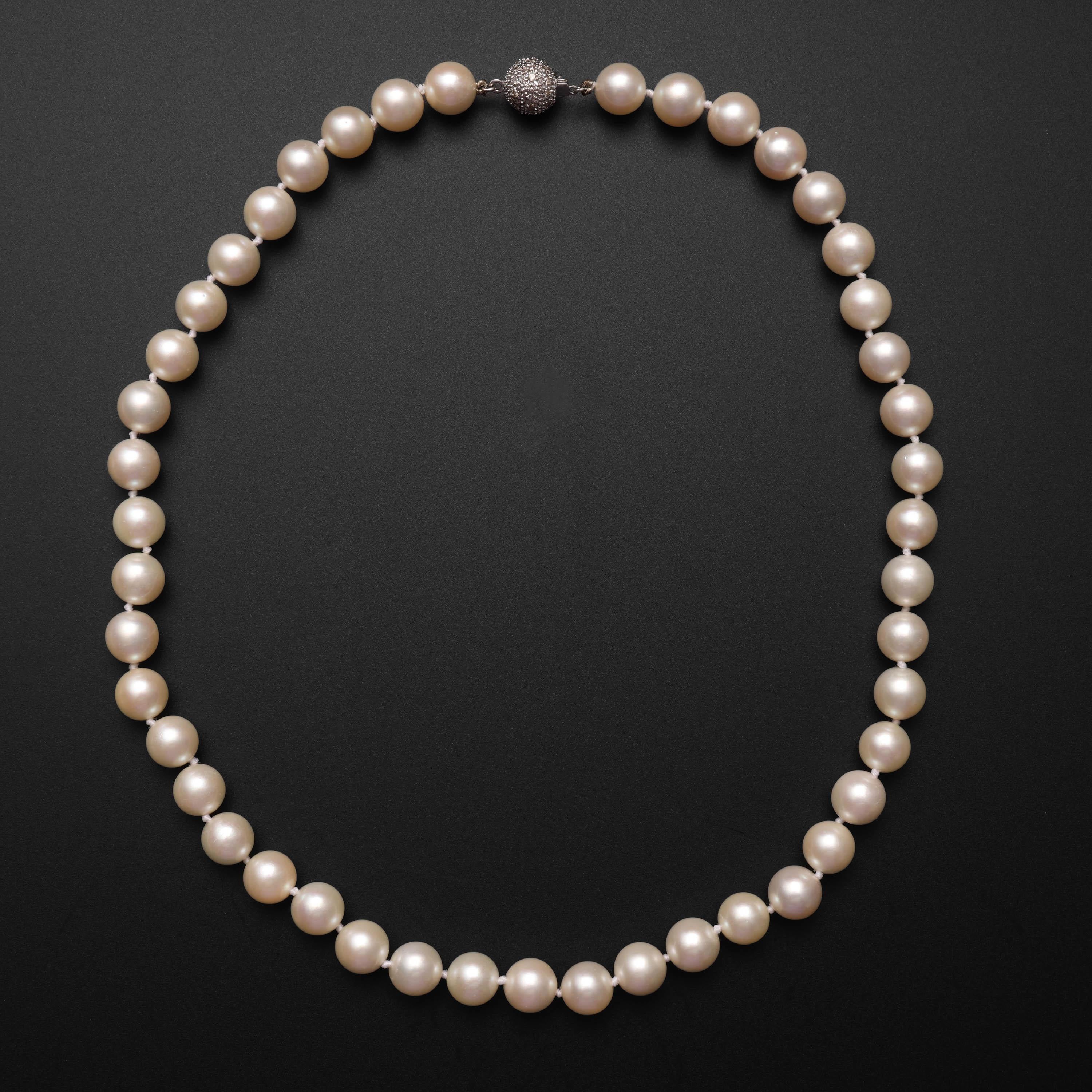 This is a stunning vintage pearl necklace measuring 18 inches in length and composed of 55 9mm-9.4mm round cultured Akoya pearls and finished with an 18K white gold beaded ball clasp which glitters with a multitude of small full-cut diamonds that