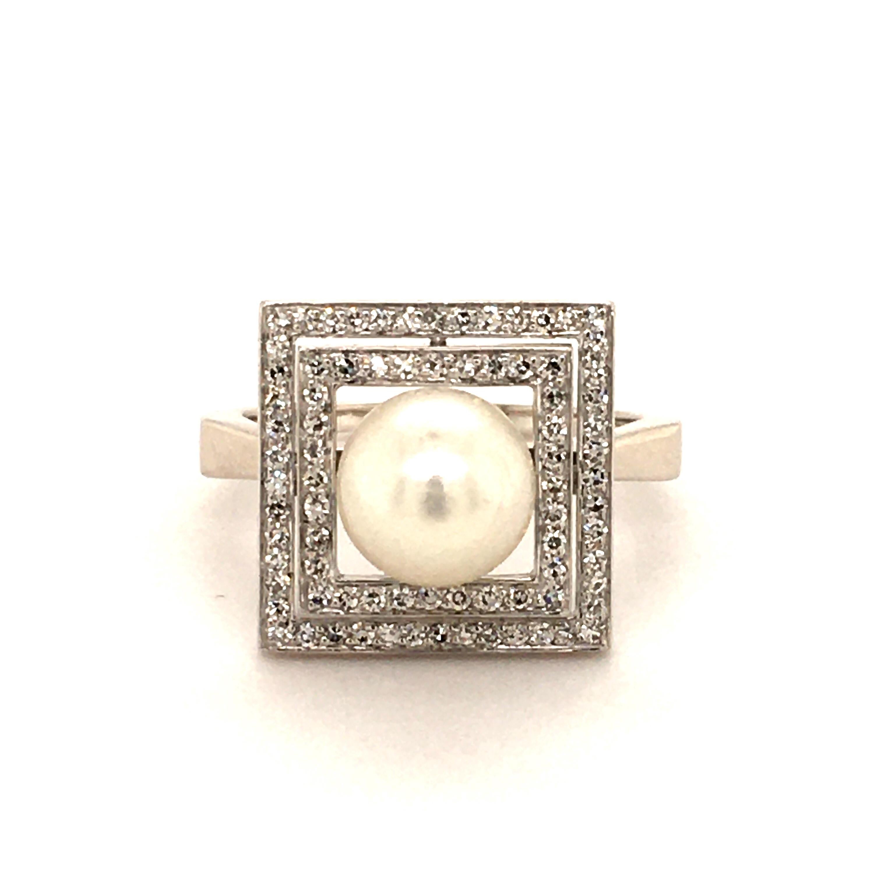 This Ring is made in White Gold 750. Set with a white Akoya-Pearl, Diameter: 8.5 mm, Form: round, Surface: slightly blemished, Luster: very good 
Surrounded by single cut diamonds (Quality: G/H-vs)
The play of shapes between angular and round