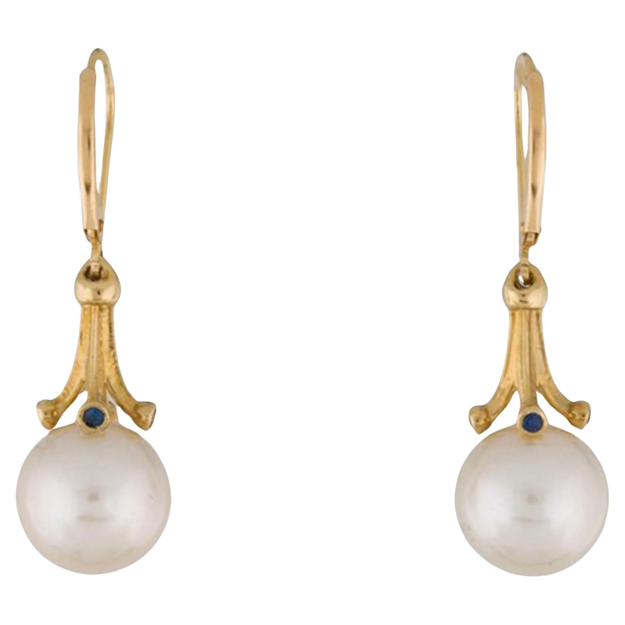    This is a beautiful 14K Yellow Gold Pearl and blue Sapphire Lever back Earrings. This pearl earring features a genuine cultured saltwater akoya pearl and round brilliant-cut sapphires. The pearls are round AAA 8.0 mm to 9 mm in size with 0.18ct