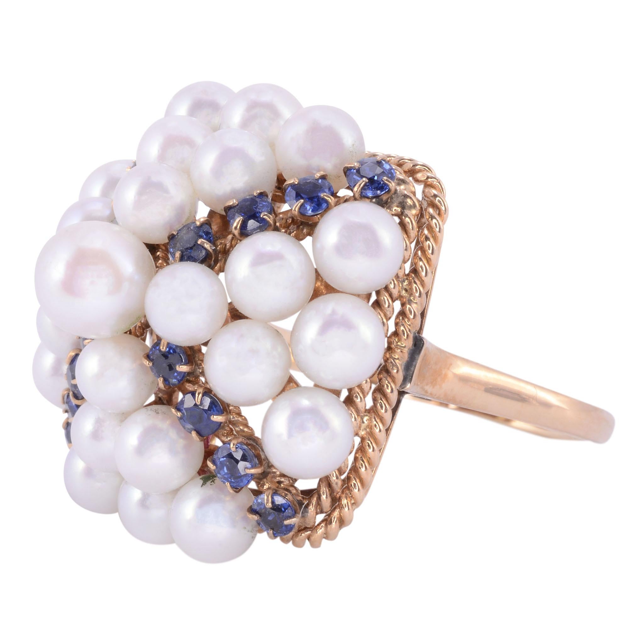 Vintage Akoya pearl & sapphire ring, circa 1955. This 14 karat yellow gold ring features a cluster of 25 Akoya cultured pearls and 16 sapphires in four rows at .96 carat total weight and is size 9.25. This vintage pearl and sapphire ring is