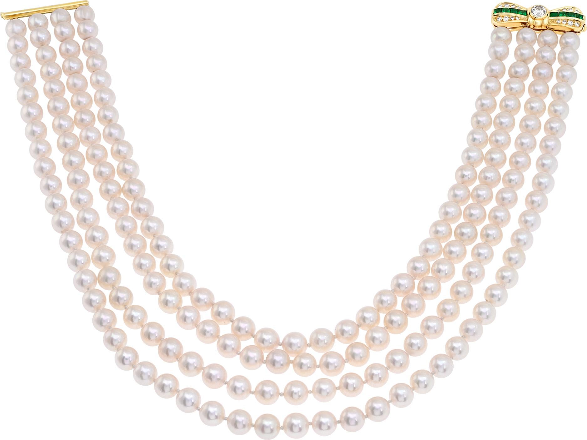 Four graduated strands of Akoya pearls (7.5 x 8mm), with round brilliant cut diamonds and square cut emerald clasp, in 18k yellow gold. Total Akoya pearls: 180 with pink hue. Center round cut brilliant diamond in bow shaped clasp approx. weight: