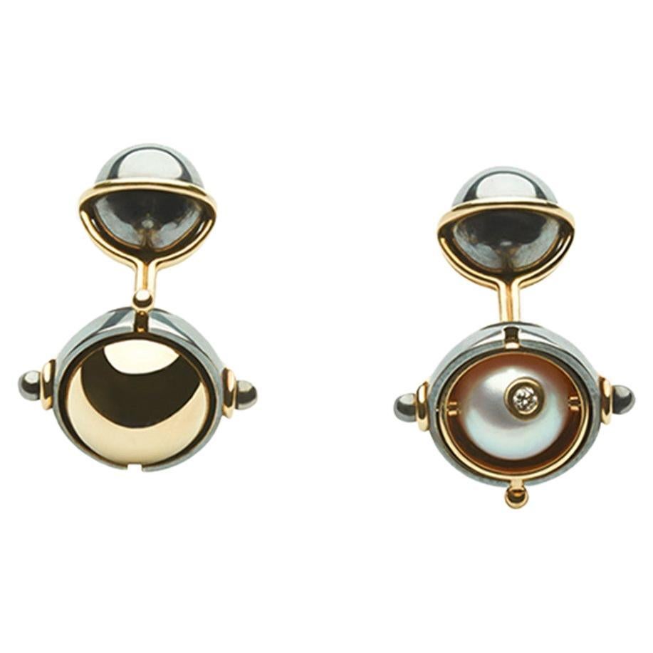 Cufflinks in yellow gold and distressed silver.  A rotating sphere revealing an akoya pearl set with a diamond. 

Details:
Akoya Pearls
2 Diamonds: 0.06 cts
18k Yellow Gold: 8 g
Distressed Silver: 6 g
Made in France