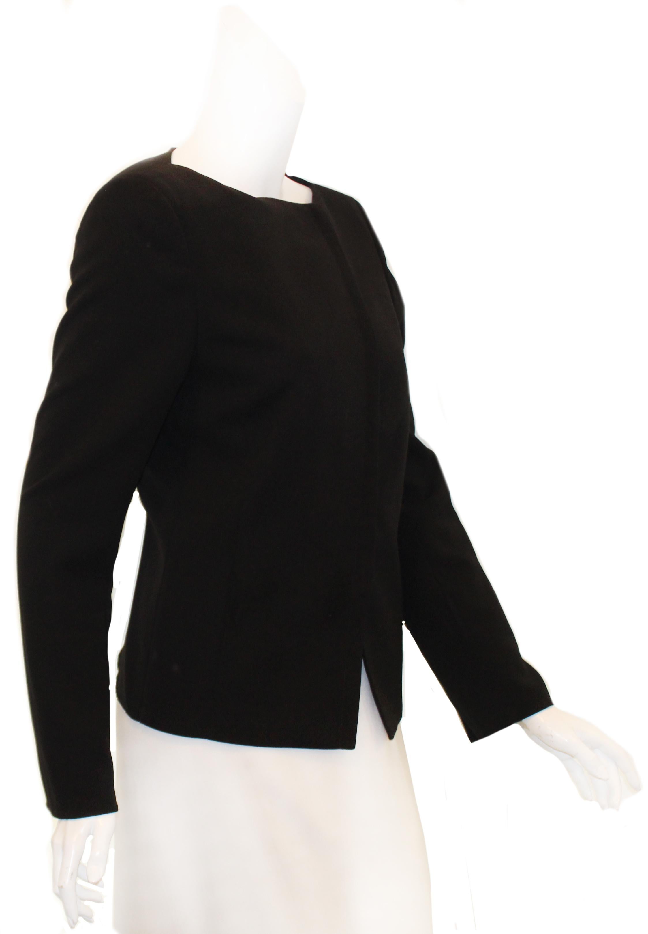Akris black wool jacket  incorporates a zipper for closure on the asymmetric front opening.  With a round collar and front slit pockets this jacket is beautifully tailored, versatile and practical to be worn with a skirt or slacks.  This jacket is