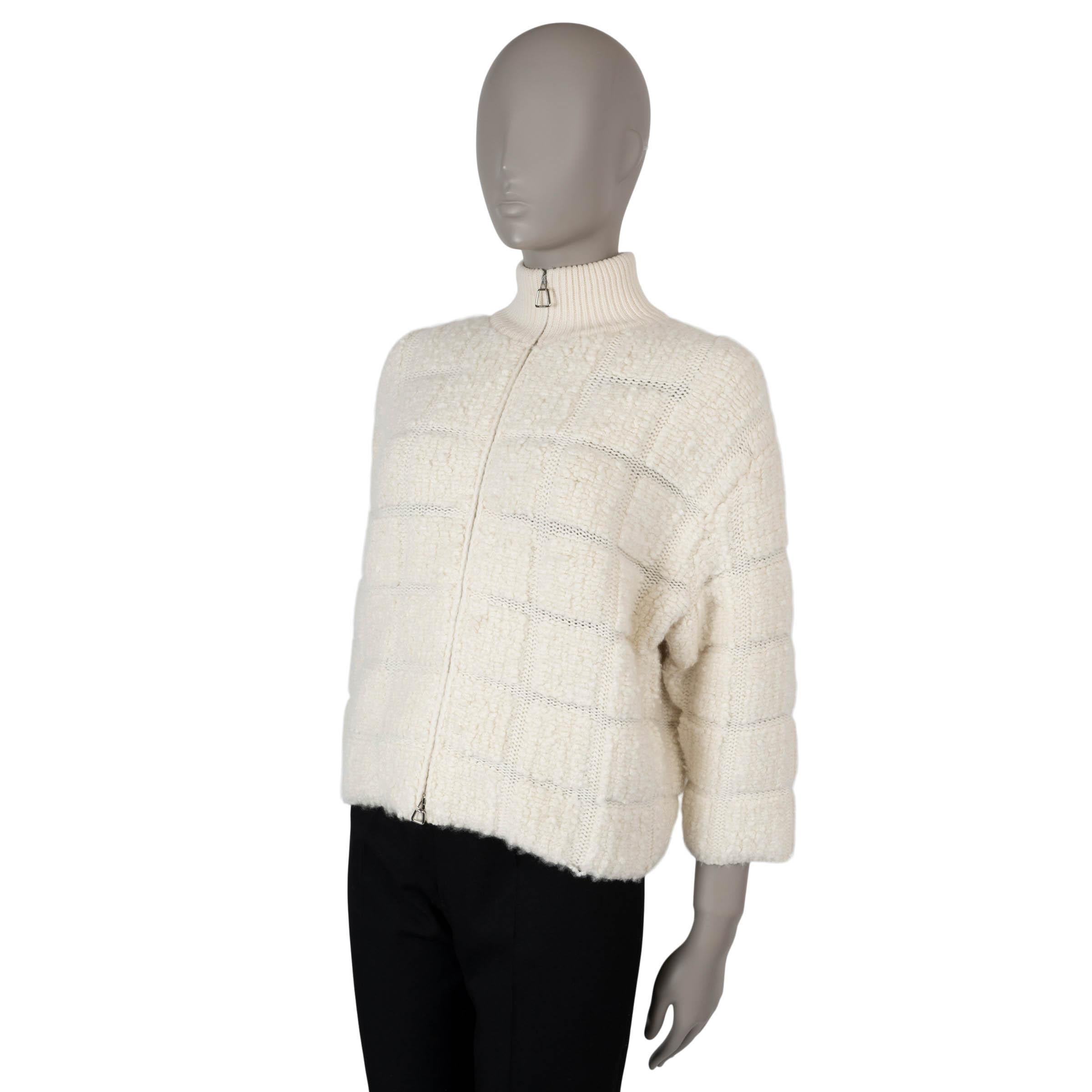 This 100% authentic AKRIS 3/4 sleeves bouclé cardigan is crafted from a luxurious blend of 95% cashmere and 5% silk, offering a soft and textured feel. The design features a boxy and slightly cropped silhouette, adding a modern and effortless touch.