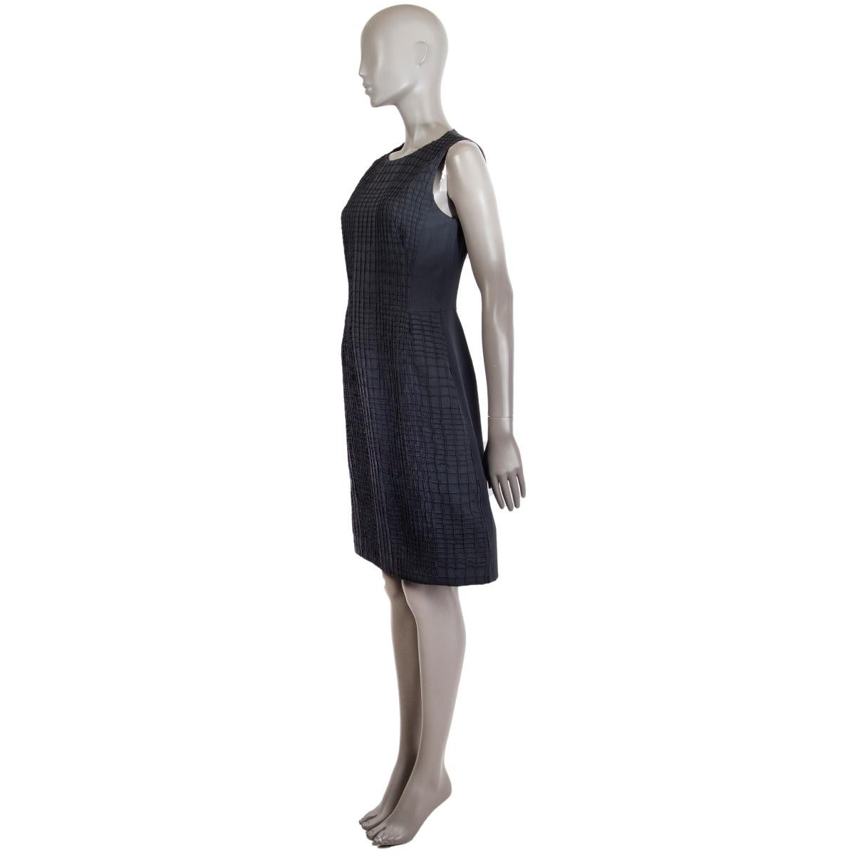 100% authentic Akris sleeveless round-neck sheath dress in dark grey wool (100%) featuring grid-textured front with extra reinforcement around the hemline for more shape. Lined in grey mulberry silk (92%) and elastane (8%). Opens with a zipper on