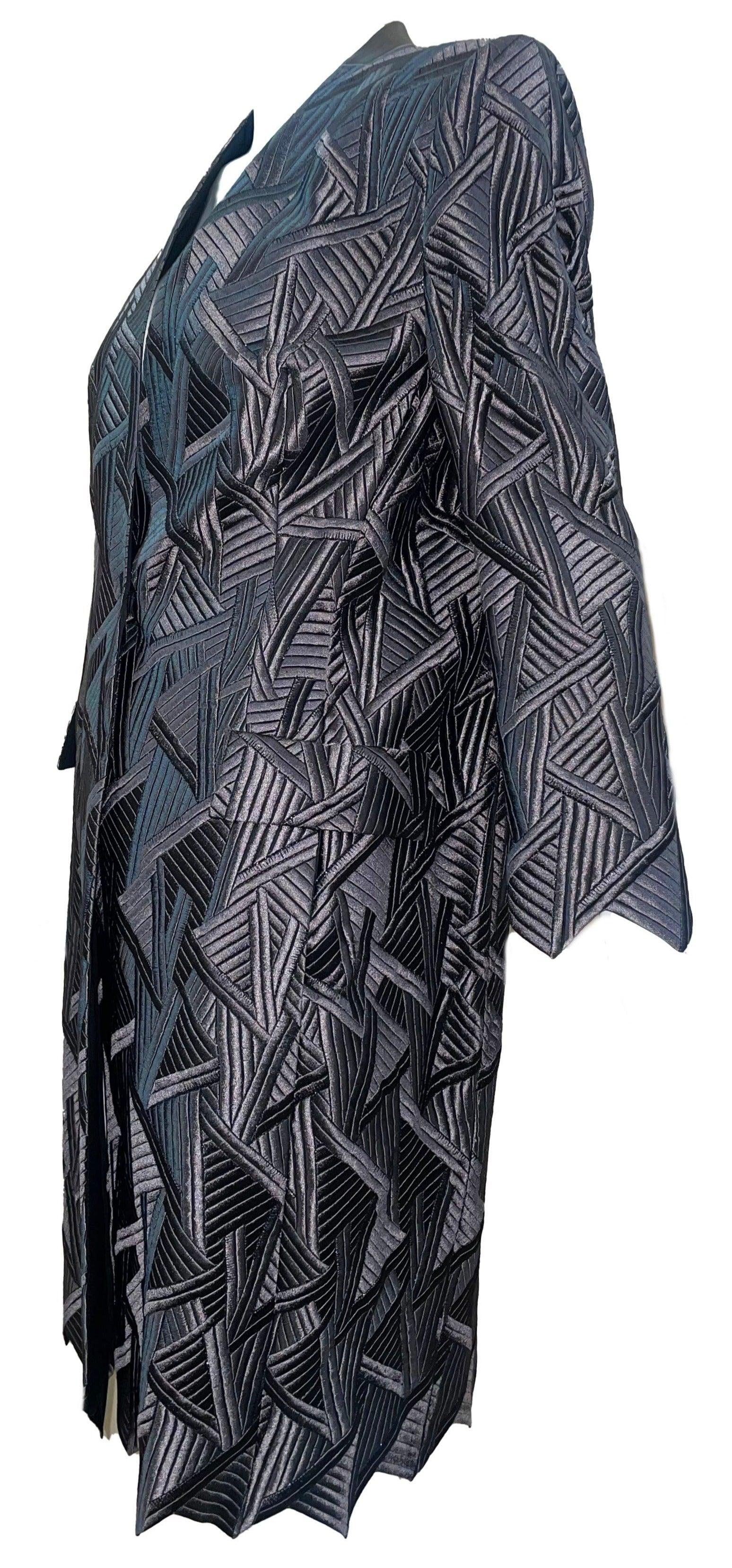 Luxurious Akris embroidered coat. Adorned with intricate embroidery in a chic gunmetal grey hue, this lightweight coat will be the perfect addition to your black tie wardrobe.  Art Deco-inspired motif and zig zag hem are statement making. Excellent