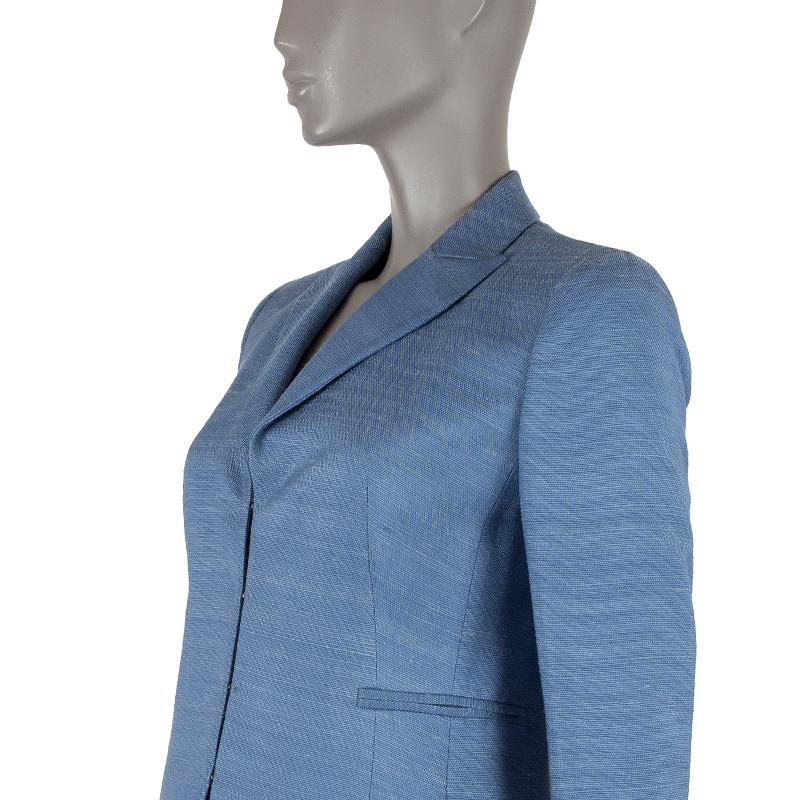 100% authentic Akris long peak-collar blazer in blue jeans silk shantung (100%). With three welt pockets on the front, two slit pockets on the sides, and slit cuffs. Closes with hooks on the front. Partially lined in blue fabric. Has been worn and