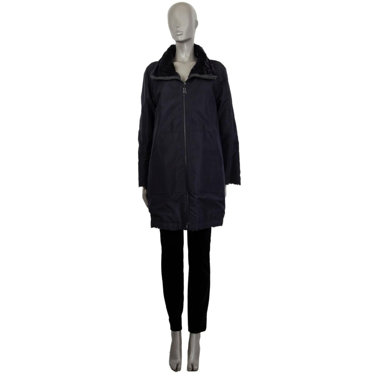 100% authentic AKRIS reversible coat in midnight blue long sheep shearling (100%) with a hidden hood in the stand-up collar and two slit-pockets in the front. Closes with a zipper in the front. The revers side is in midnight blue viscose (100%) with