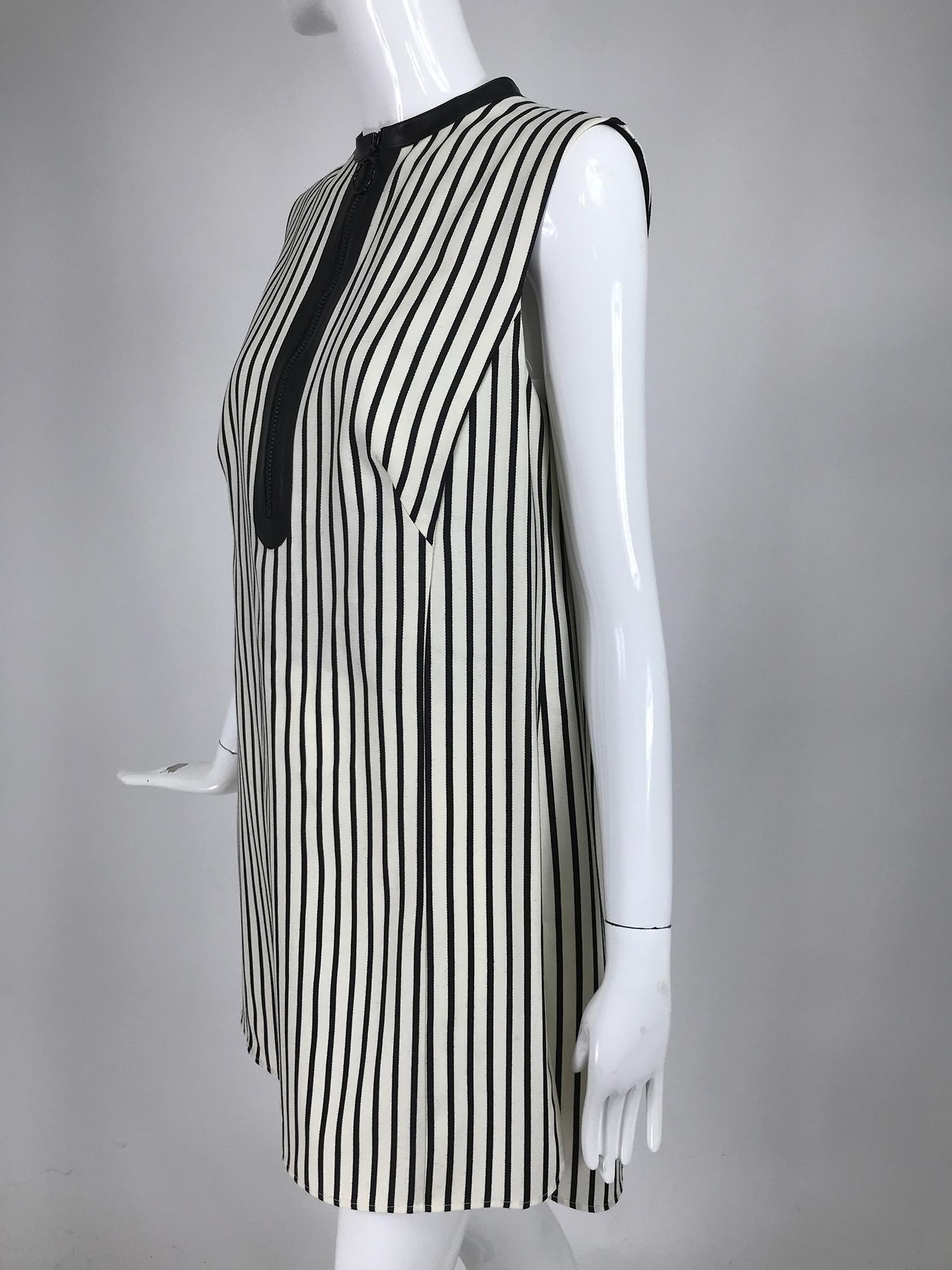 Akris Punto black and white stripe zipper front tunic. Sleeveless tunic of fine soft wool twill has placket front and neck trim of black vinyl with a chunky black zipper. Bust side darts and side hem vents, the top has shirt tail hem and is longer