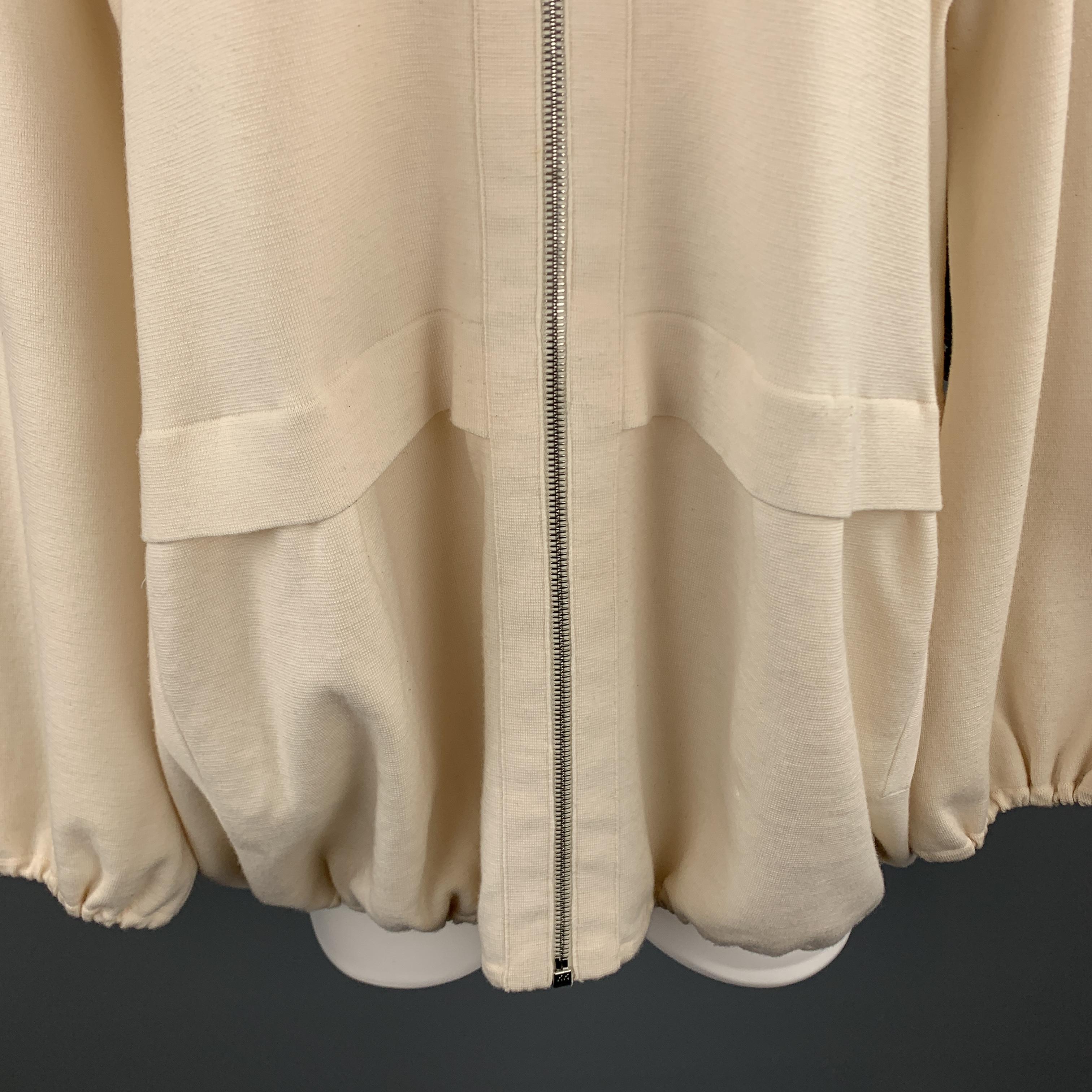 AKRIS sweater jacket comes in cream wool blend knit with a high neck, zip front, and elastic drawstring hems. Wear on front. As-is. 

Good Pre-Owned Condition.
Marked: US 14

Measurements:

Shoulder: 17.5 in.
Bust: 44 in.
Sleeve: 24 in.
Length: 28