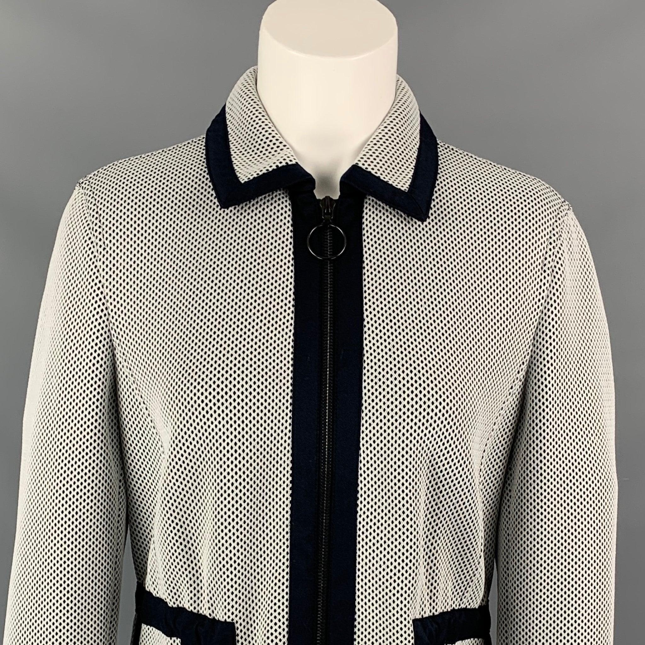AKRIS jacket comes in a white mesh polyester / nylon with a navy trim featuring a spread collar, drawstring, spread collar, and a full zip up closure.
 Very Good
 Pre-Owned Condition. 
 

 Marked:  US 6 / F 38 / D 36 / UK 10 / IT 42 
 

